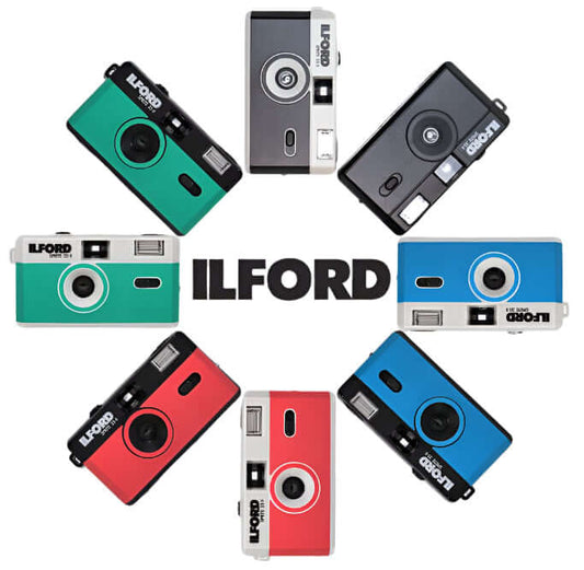 Ilford Sprite 35-II refillable 35mm cameras in various colors arranged around the brand name, showcasing their fun design.