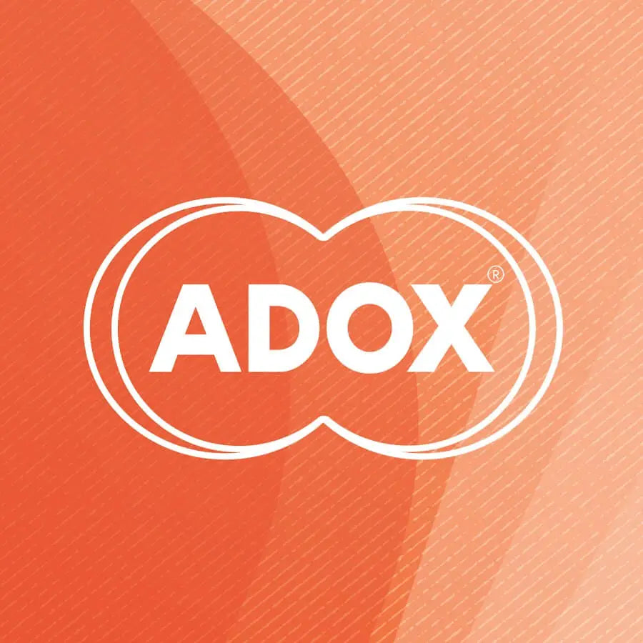 White ’adox’ logo with a distinctive double-oval outline, set against an orange gradient background.