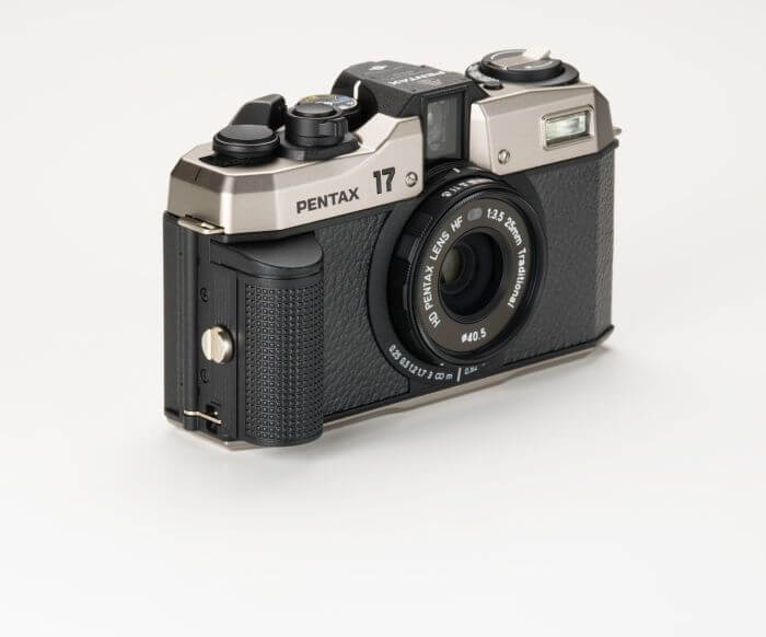 Black and silver pentax 17 film camera with a textured grip and a mounted lens.