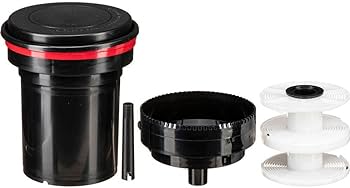 Film developing tank with reels and accessories for traditional film processing.