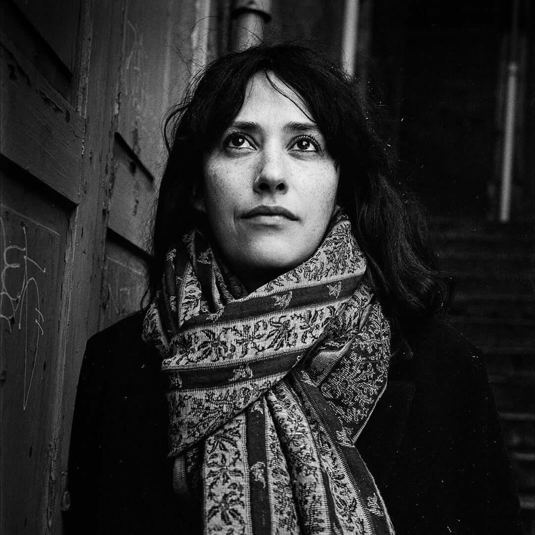 Woman with scarf in black and white photography, captured on BERGGER Pancro 400 film showing exceptional grain structure and contrast.