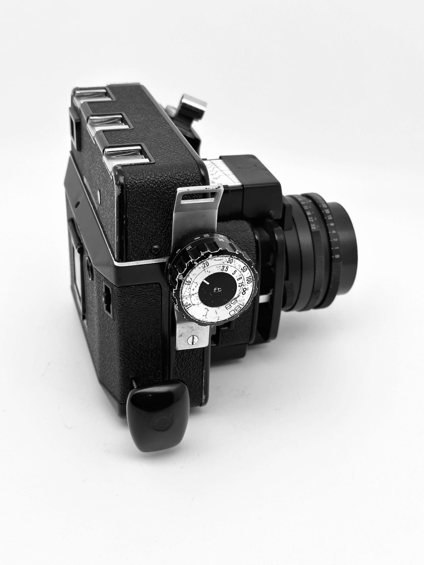 Vintage Koni Rapid Omega 6x7 film camera with 90mm f/3.5 lens, showing wear and tear, side view on white background.