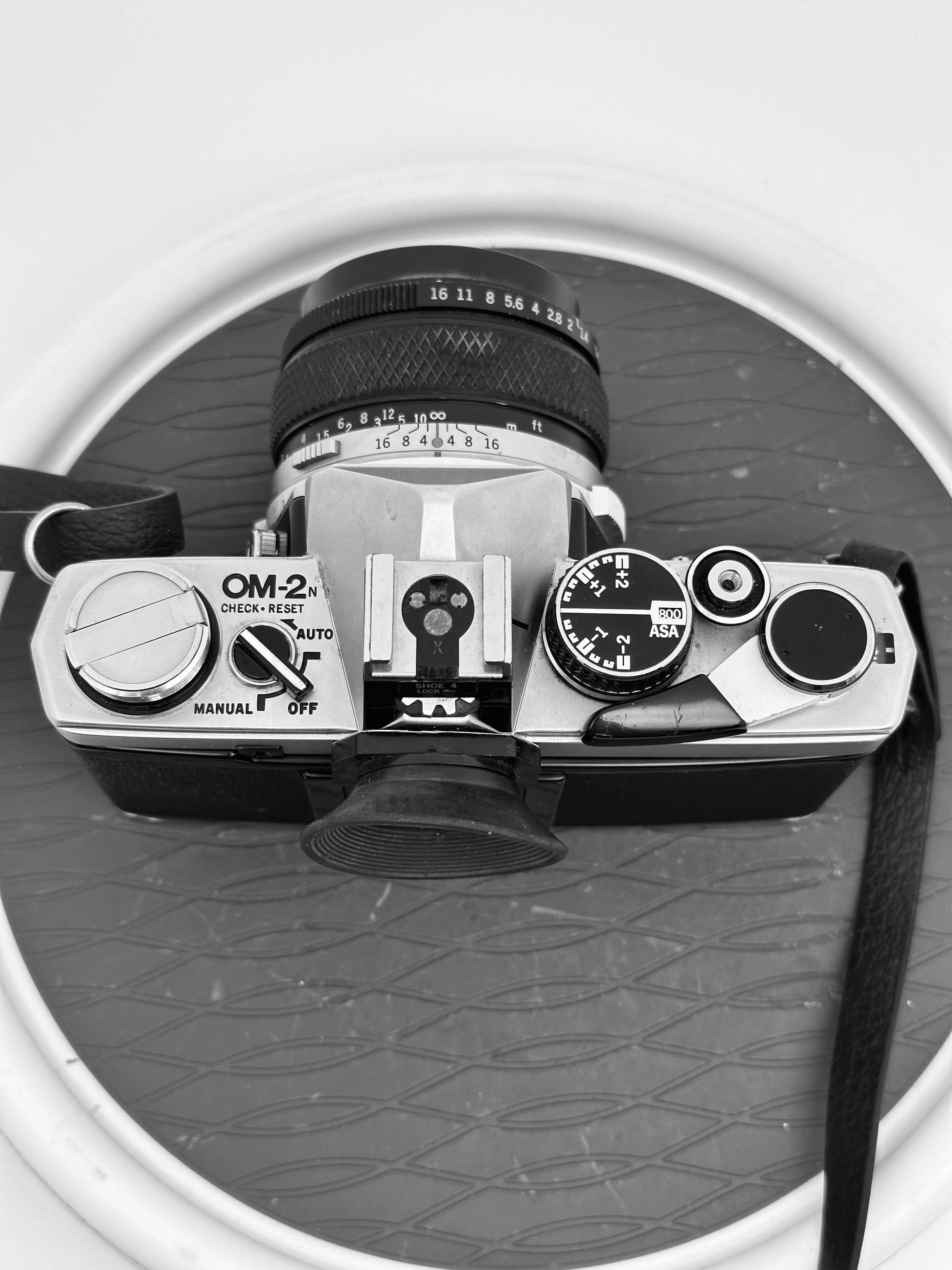 Top view of vintage Olympus OM-2N 35mm film camera with 50mm f/1.4 lens showing its controls and dials.