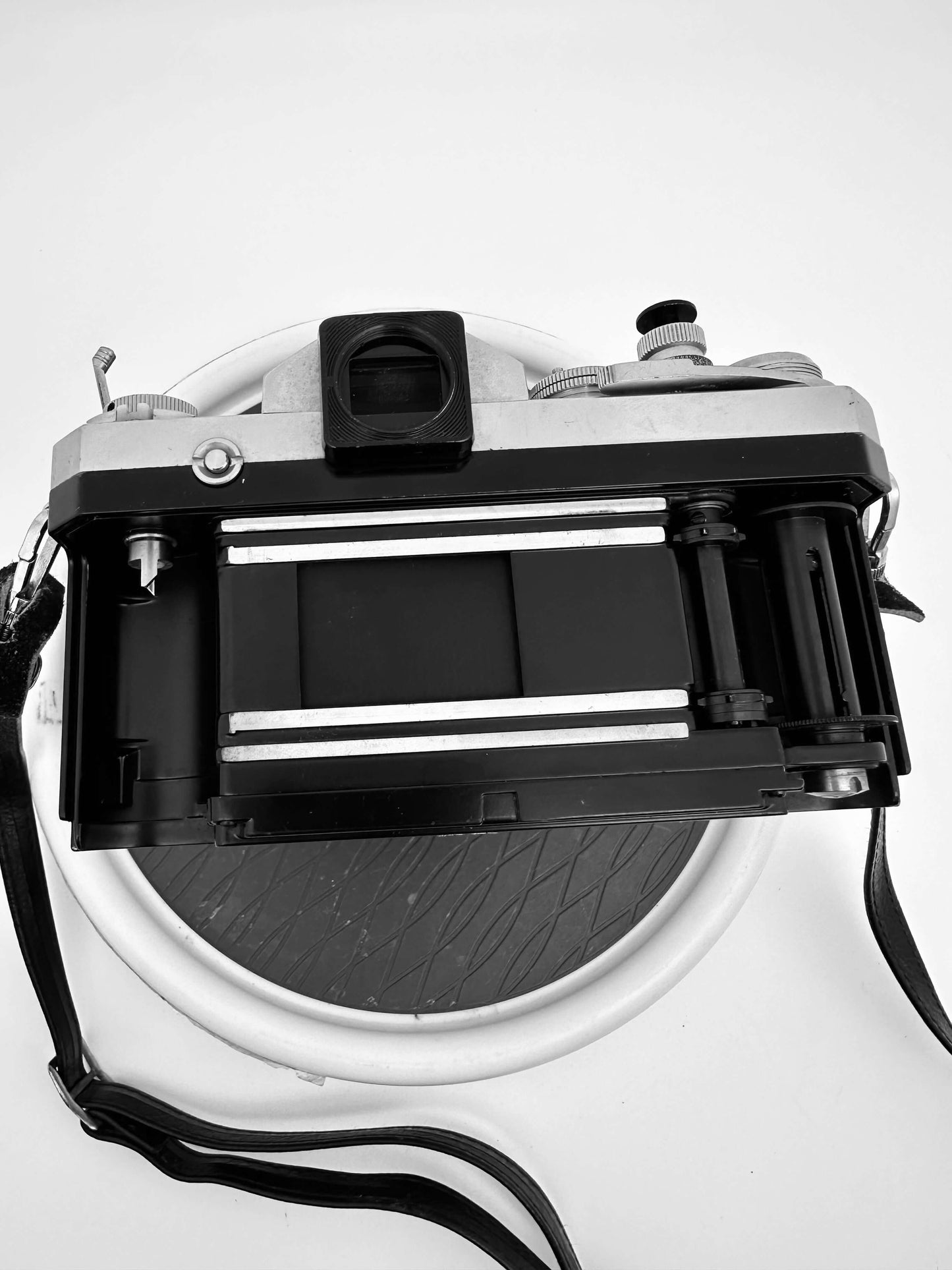 Back view of Nikon F 35mm film camera with Nikkor 43-86mm f/3.5 lens, showcasing open film compartment in used condition.