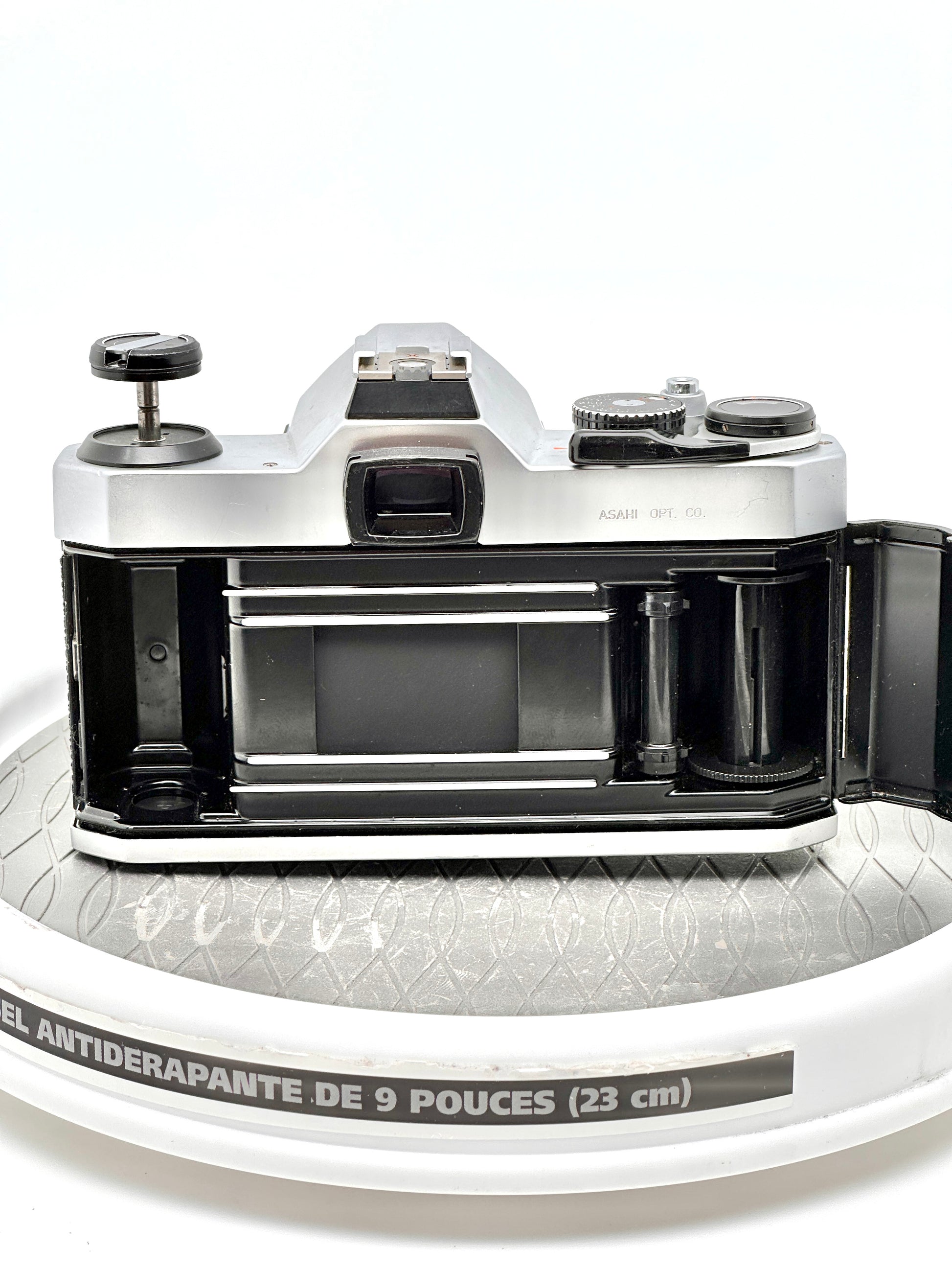 Pentax K1000 35mm film camera showing the open back and film compartment for loading and unloading film.