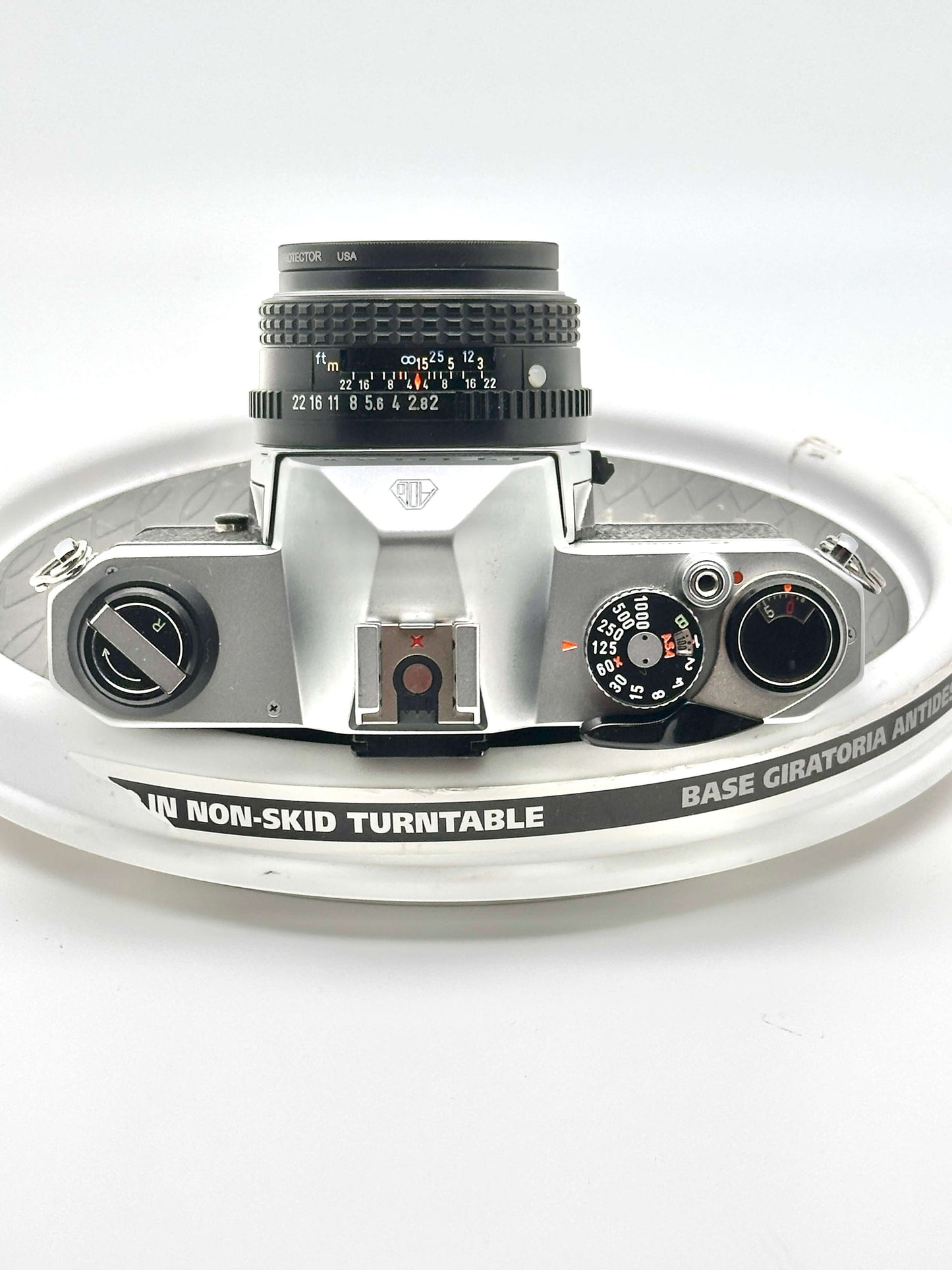 Japanese Pentax K1000 35mm film camera with 50mm lens, showcasing its classic design and controls on a turntable.