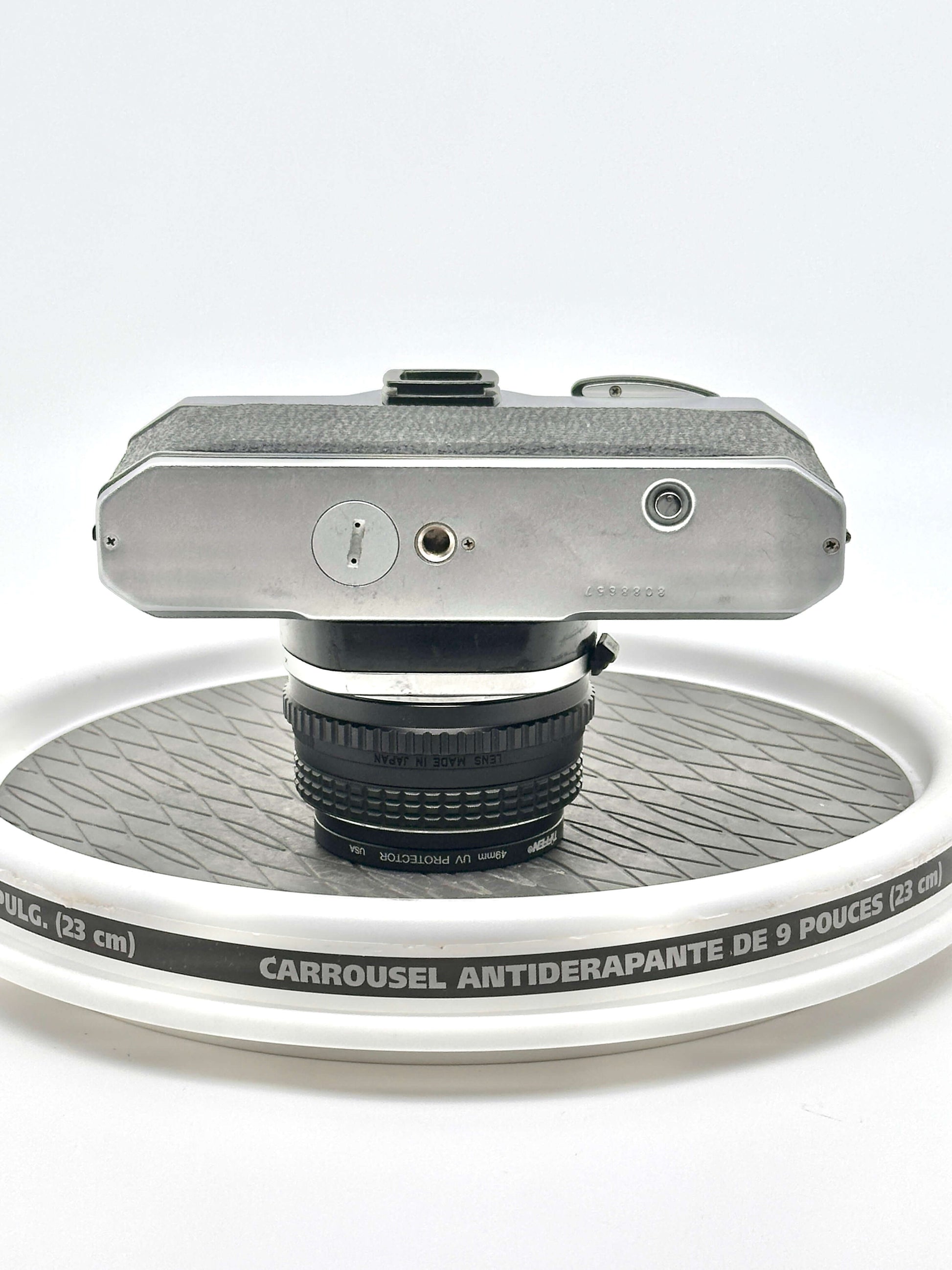 Japanese Asahi Pentax K1000 black used 35mm film camera viewed from the rear with 50mm f1.7 lens on a rotating display.