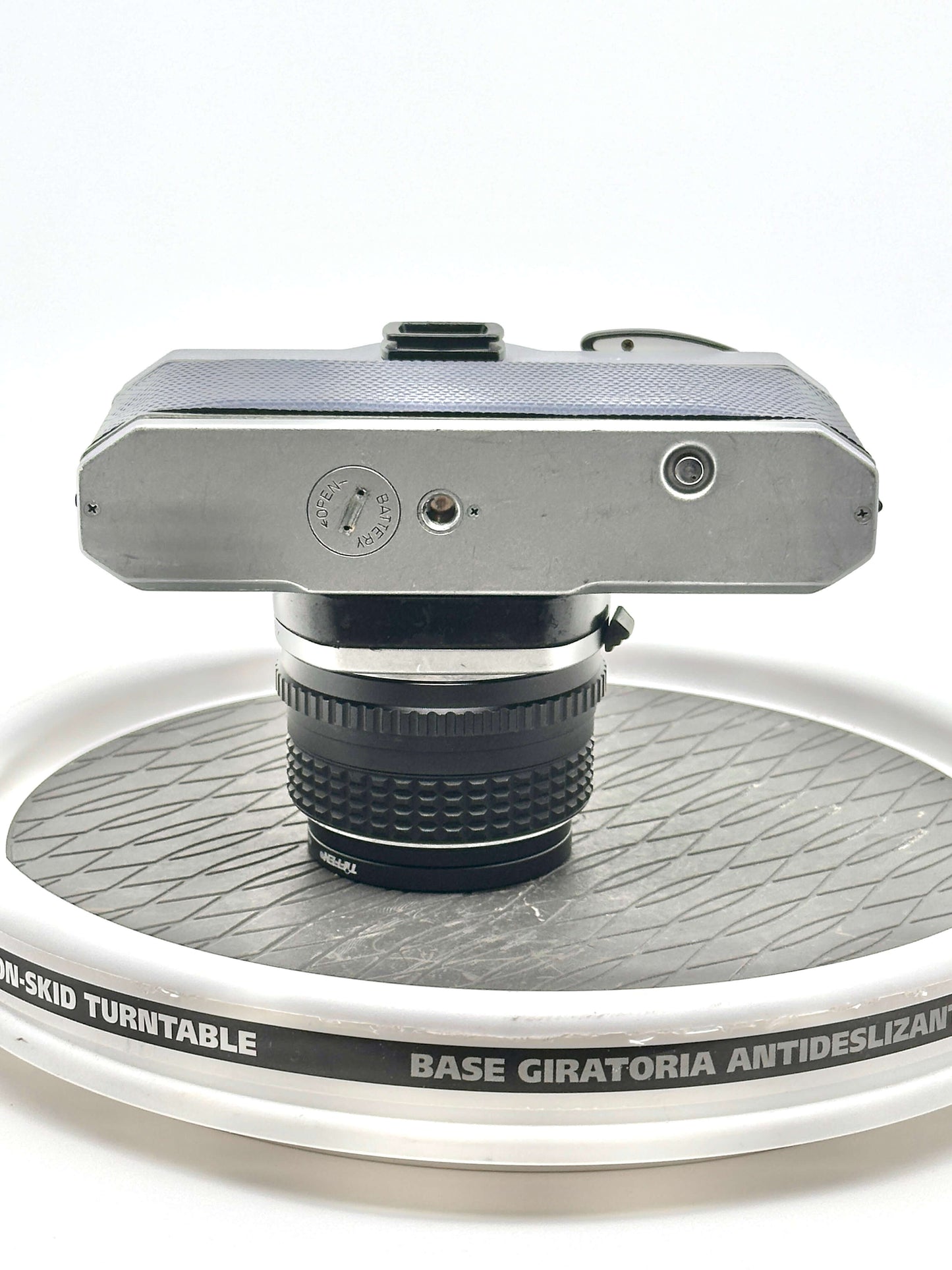 Top view of used Japanese Asahi Pentax K1000 camera on a non-skid turntable, showcasing 50mm f1.4 lens detail.