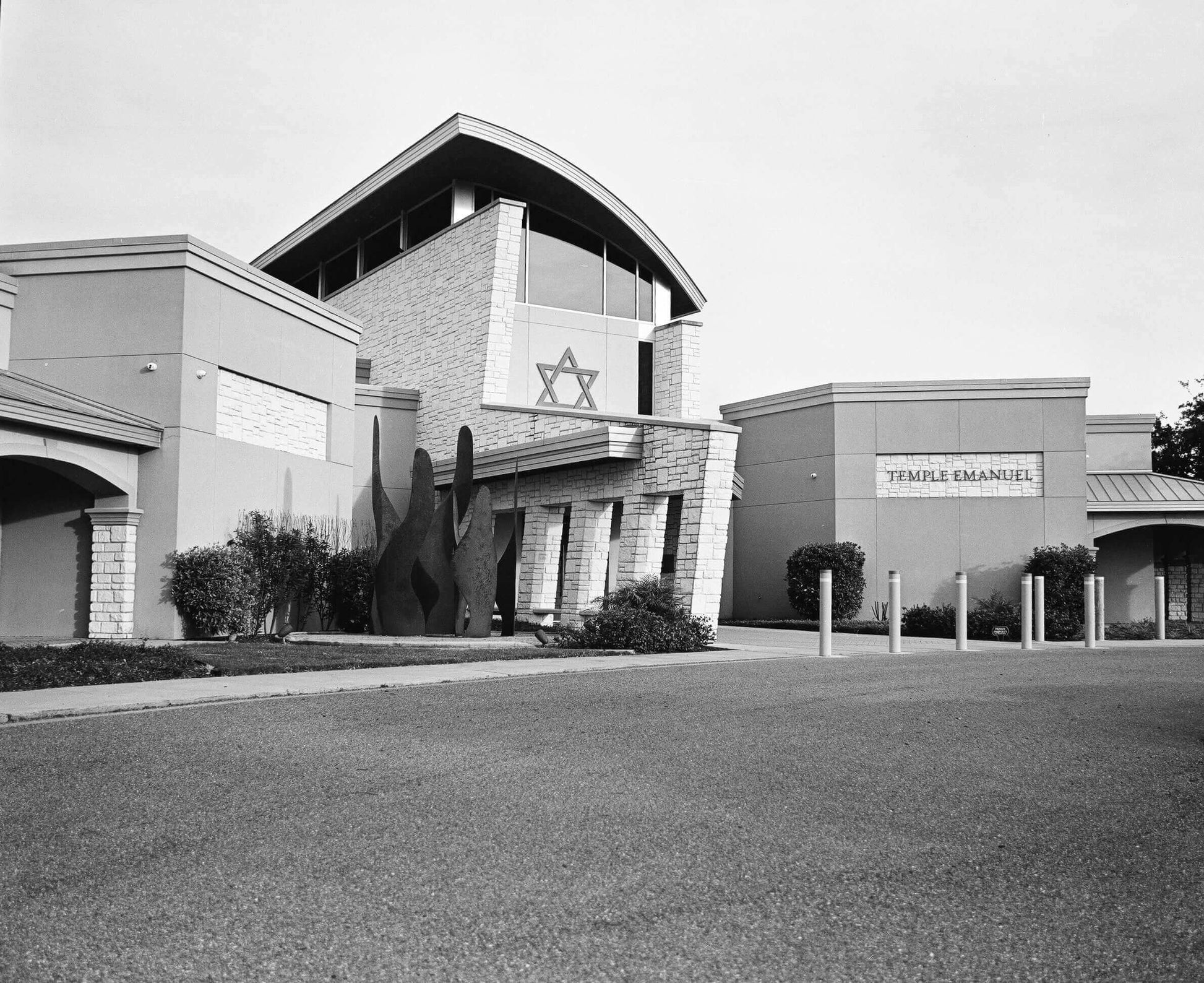 Modern architecture of Temple Emanuel synagogue with Star of David symbol in black and white photograph.