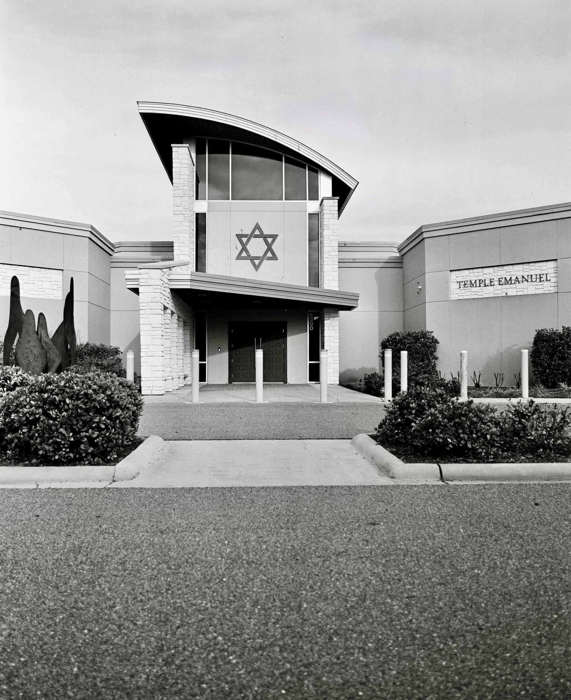 Modern architectural building of Temple Emanuel with prominent Star of David and landscaped surroundings in black and white.