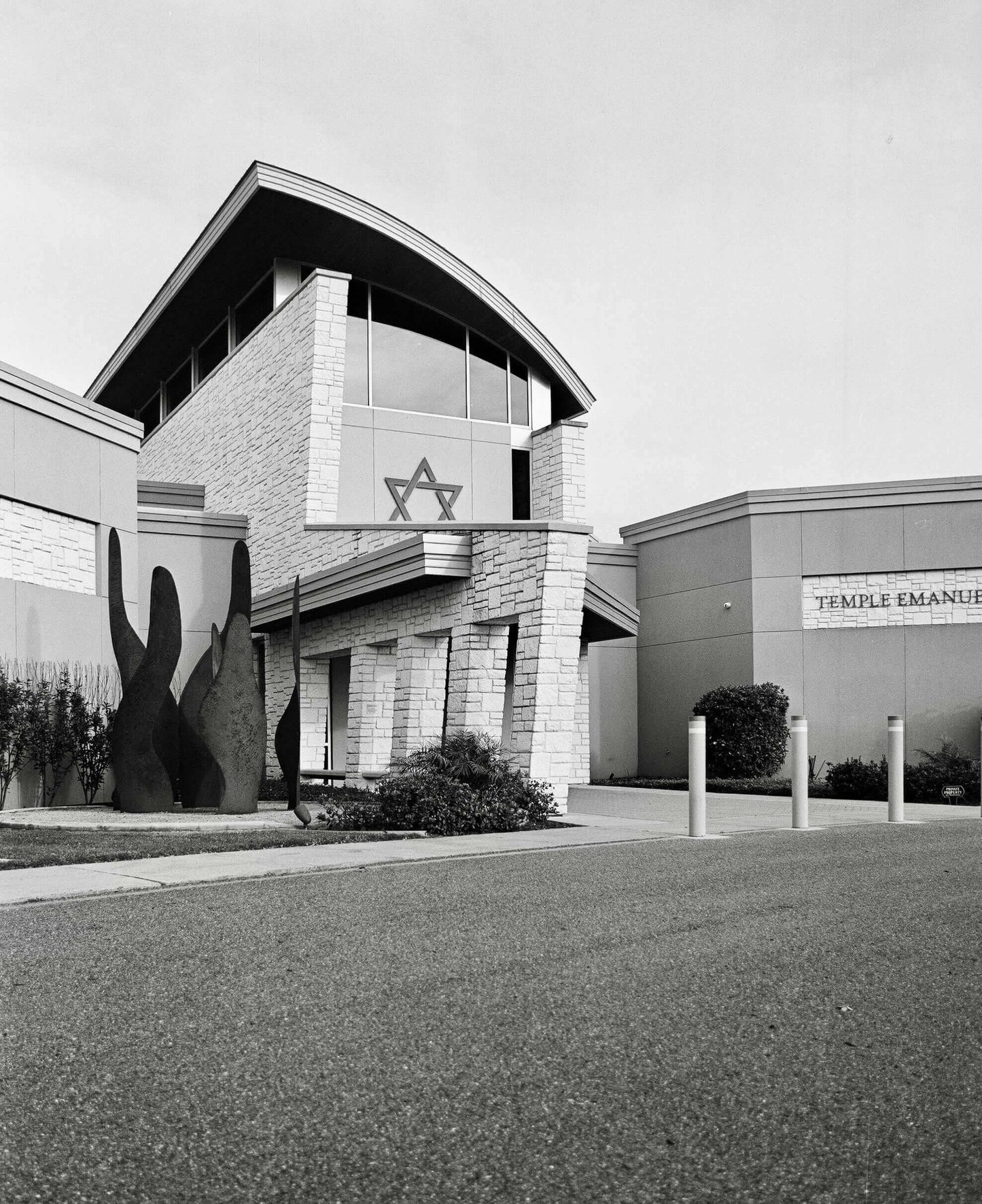 Modern architectural design of Temple Emanu-El with a prominent Star of David emblem on the building facade.