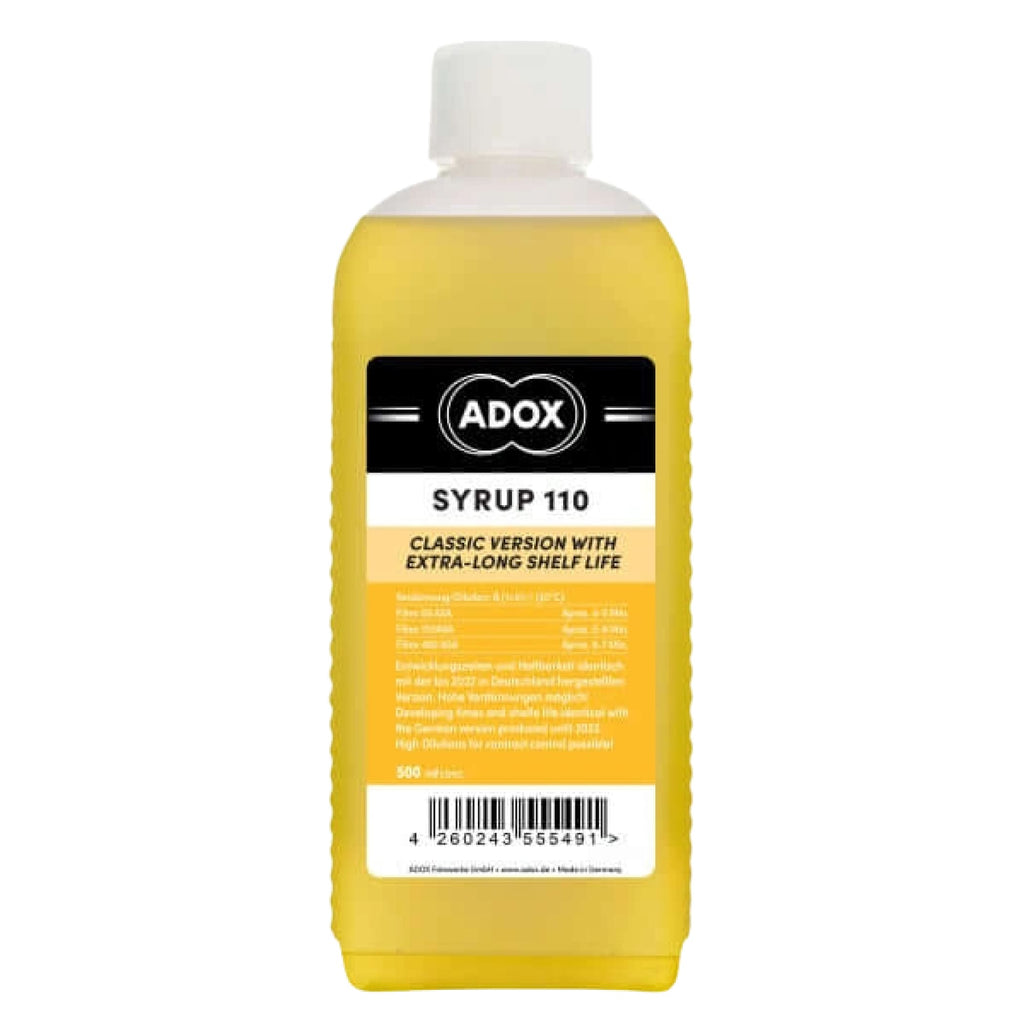 A yellow adox syrup 110 bottle with a white cap and an orange label featuring black text.