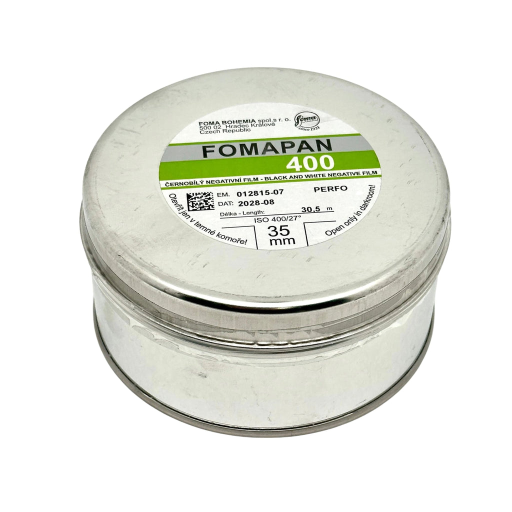 A cylindrical silver metal canister containing fomapan 400 black and white negative film, labeled with green and gray branding.