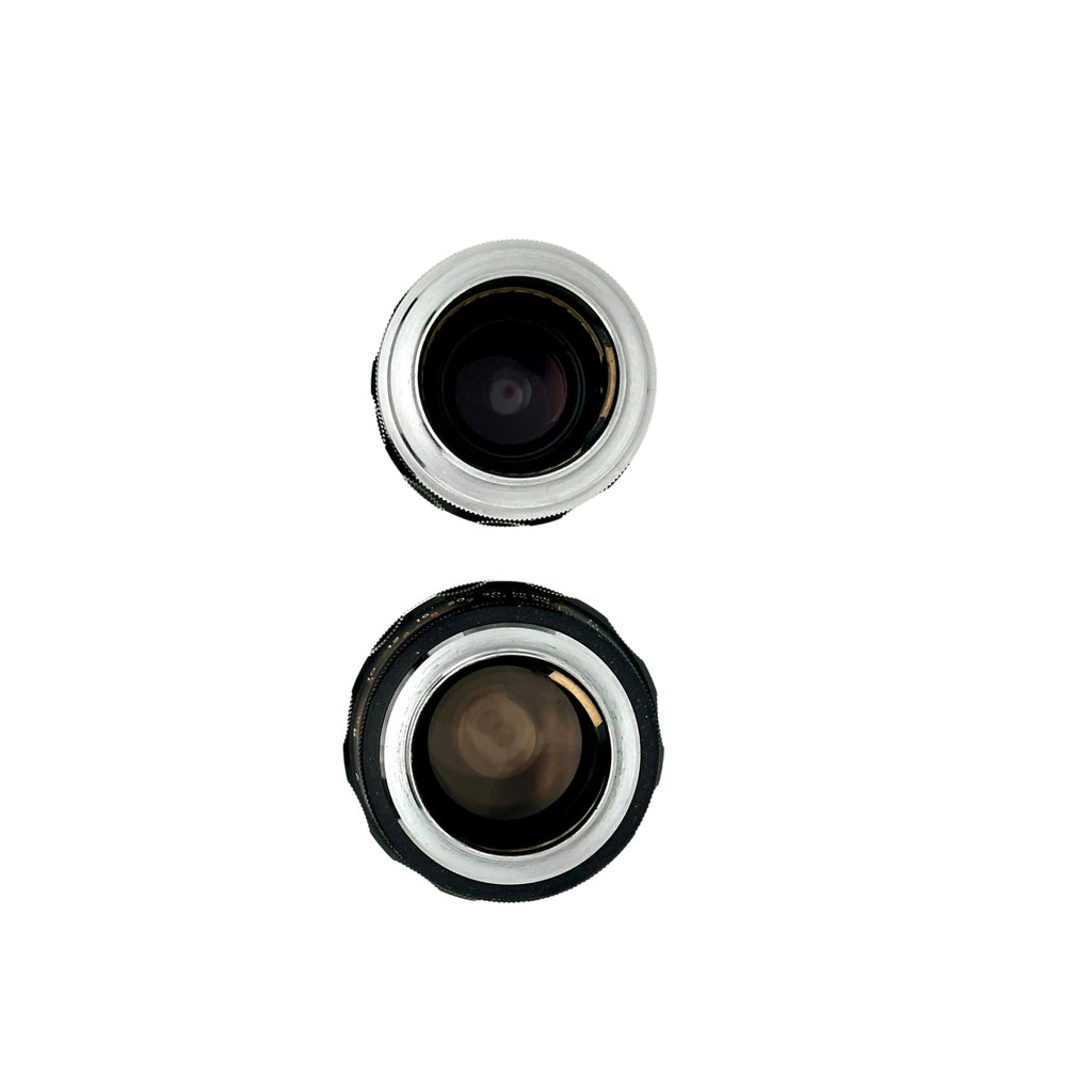 Two vintage camera lenses, one with a silver metallic rim and the other in black rubberized housing.