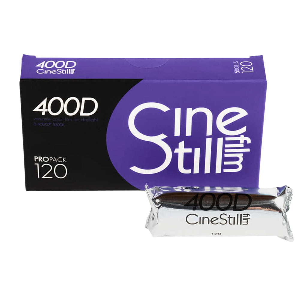 Purple and black cinestill 400d film pack with a silver-wrapped roll of 120mm color negative film.