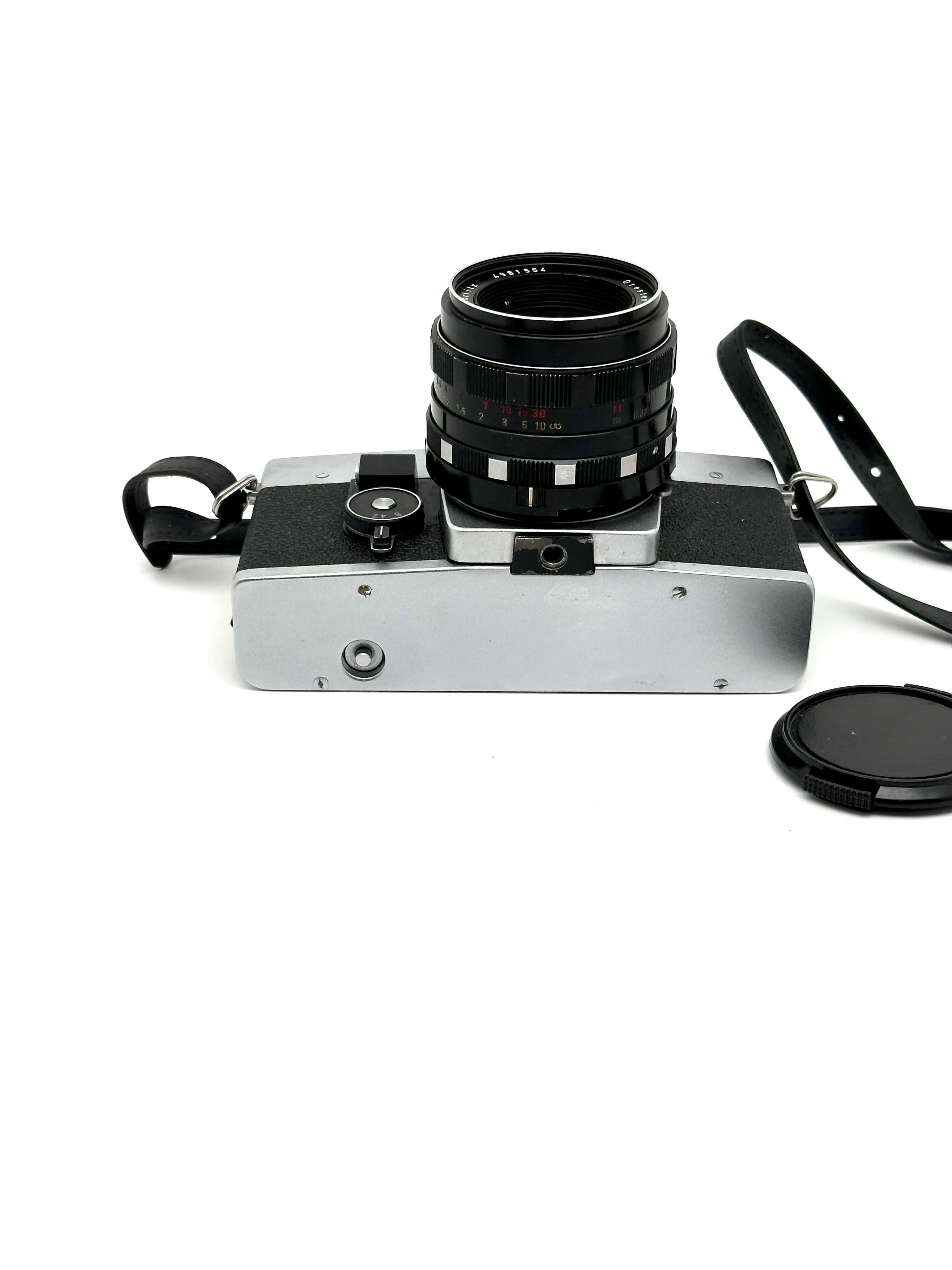 Exakta RTL 1000 vintage 35mm film camera with lens and strap, showcasing classic design by Pentacon.