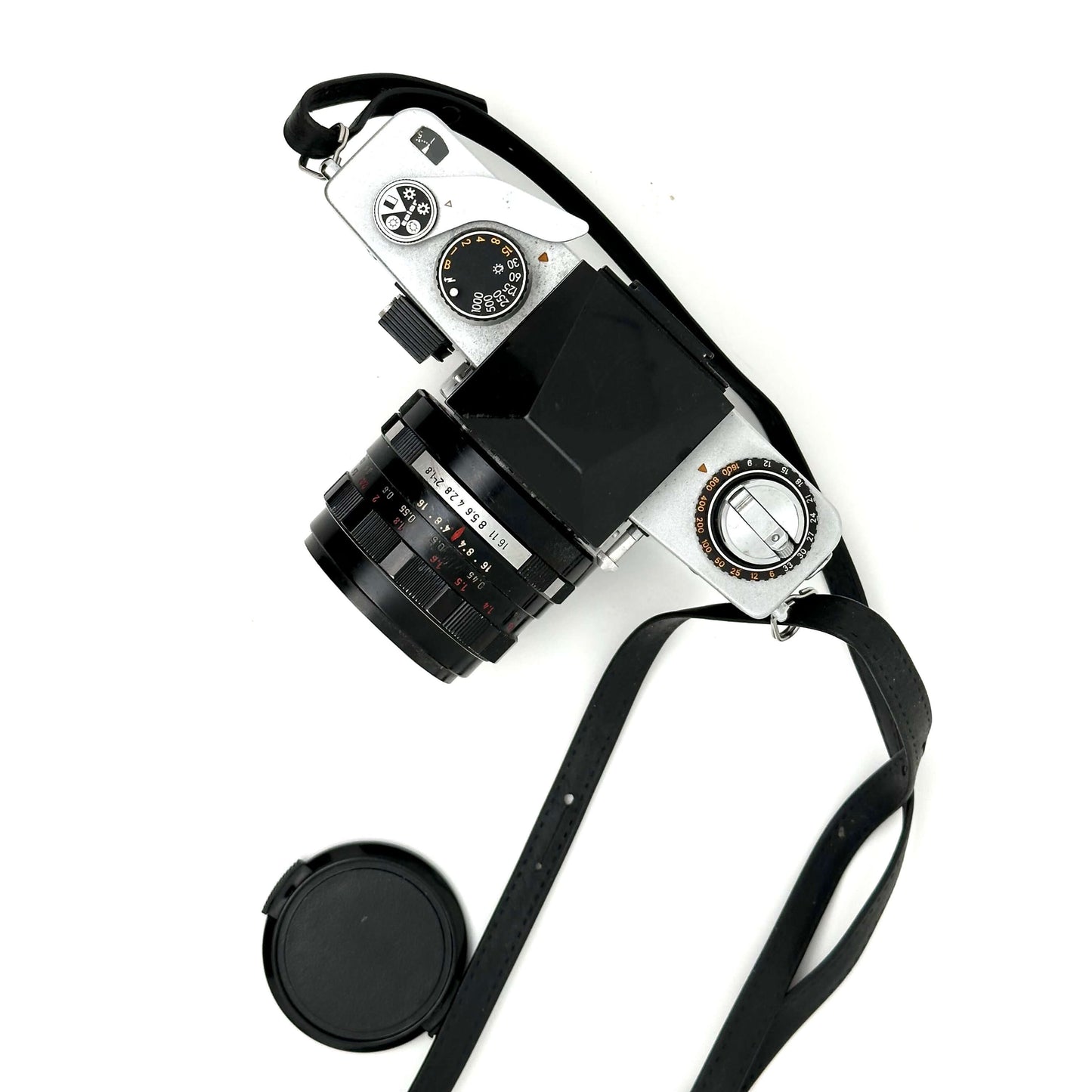 Exakta RTL 1000 vintage 35mm film camera with lens and strap, top view on white background.