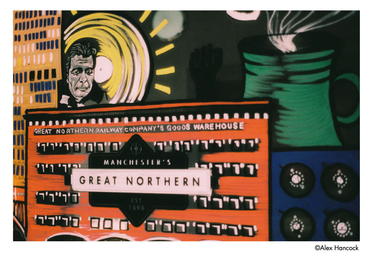 Image of Great Northern Railway Company's Goods Warehouse with colorful art and a portrait of a man.