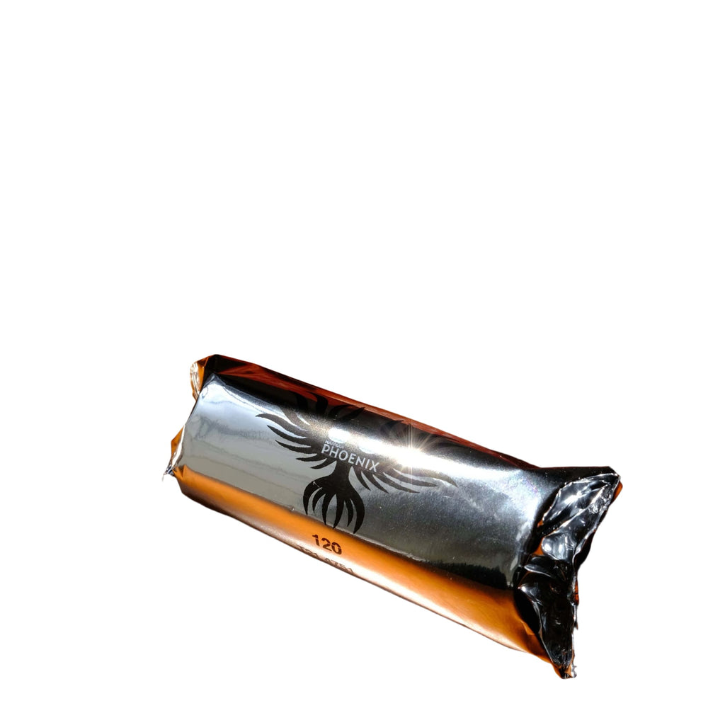 A roll of harman phoenix iso 200 colour film wrapped in reflective silver foil with a black phoenix logo.