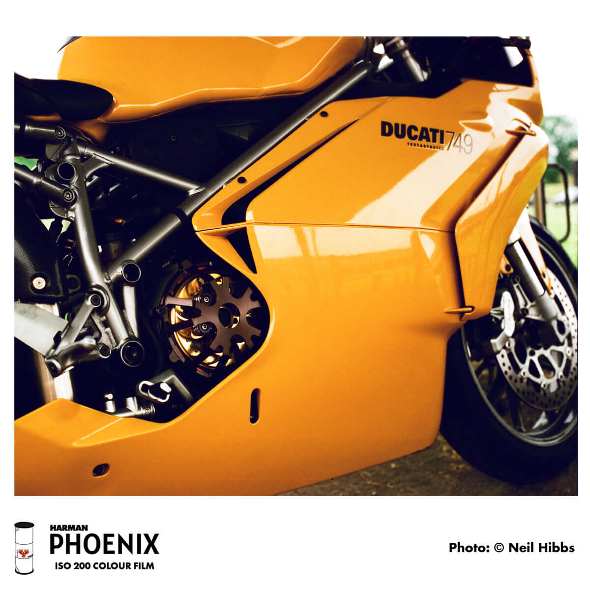 Close-up of a Ducati 749 motorcycle in vibrant yellow, showcasing detail and design, shot on HARMAN Phoenix 200 color film.