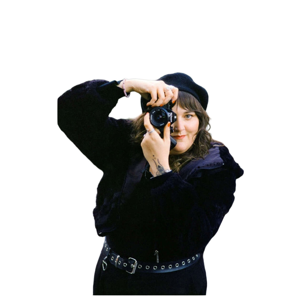 Black nikon camera with a lens cap on the front