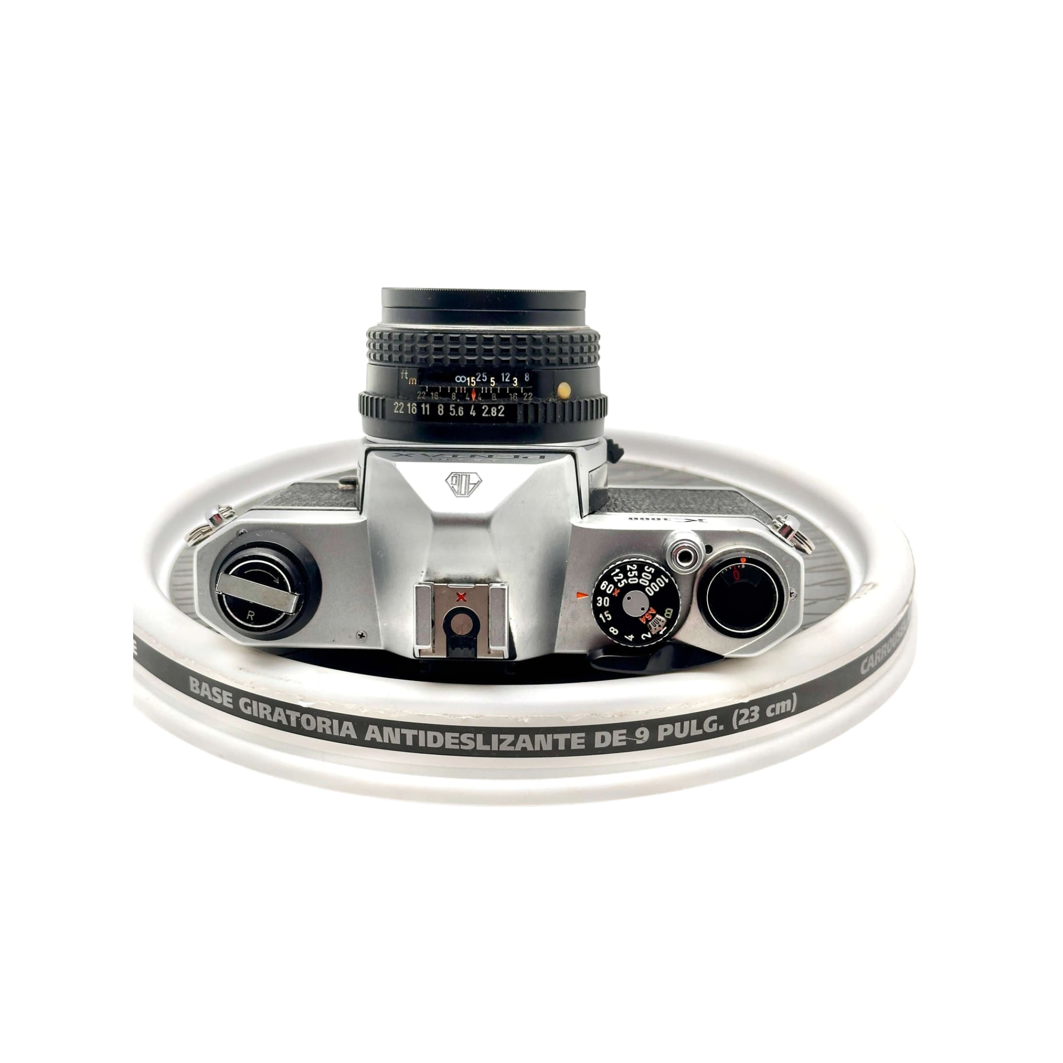 Silver-bodied canon ae-1 film camera with a black lens and textured dials.