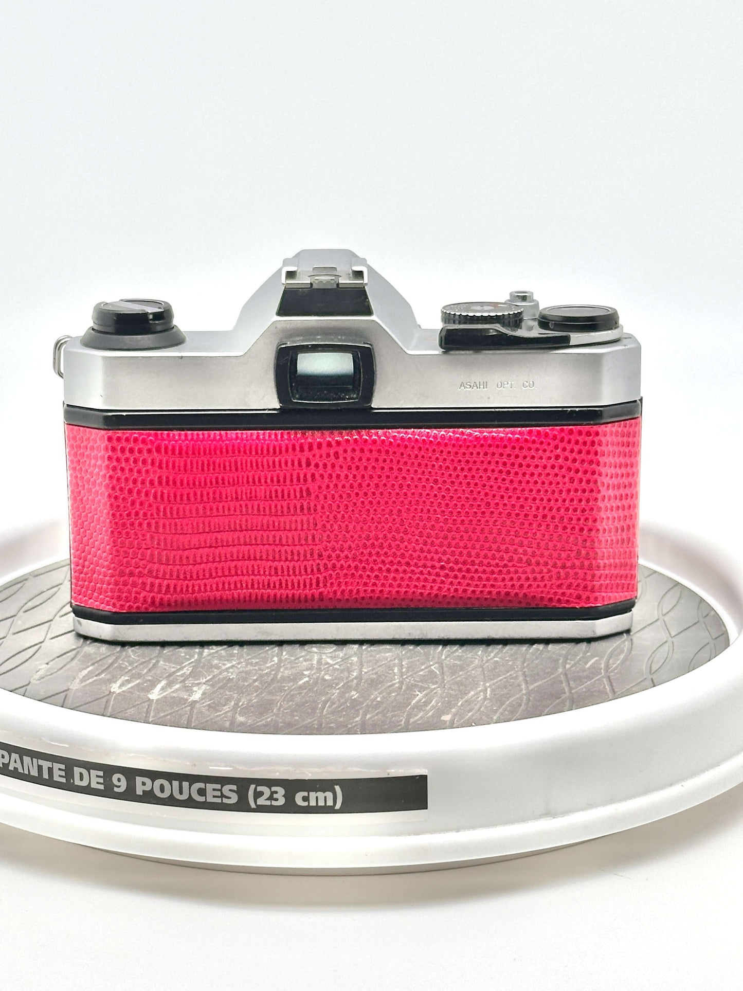 Rear view of a vibrant red Japanese Asahi Pentax K1000 35mm film camera on a display.