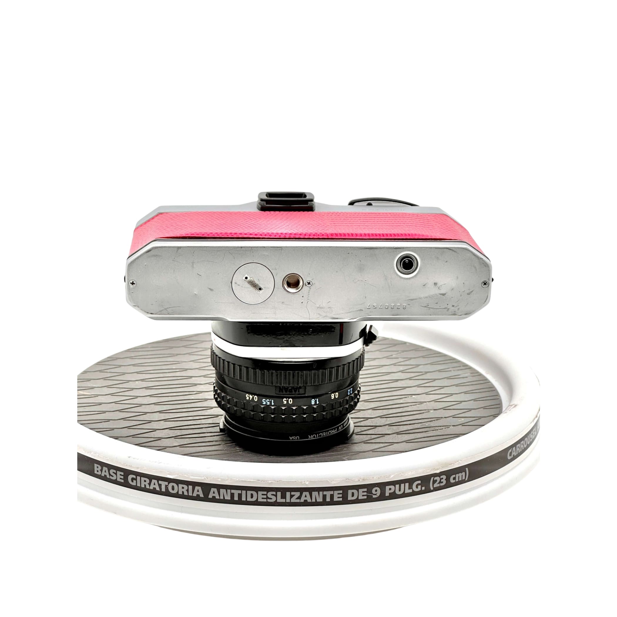 Pink leather-bodied vintage camera with a silver metal top plate and black lens.