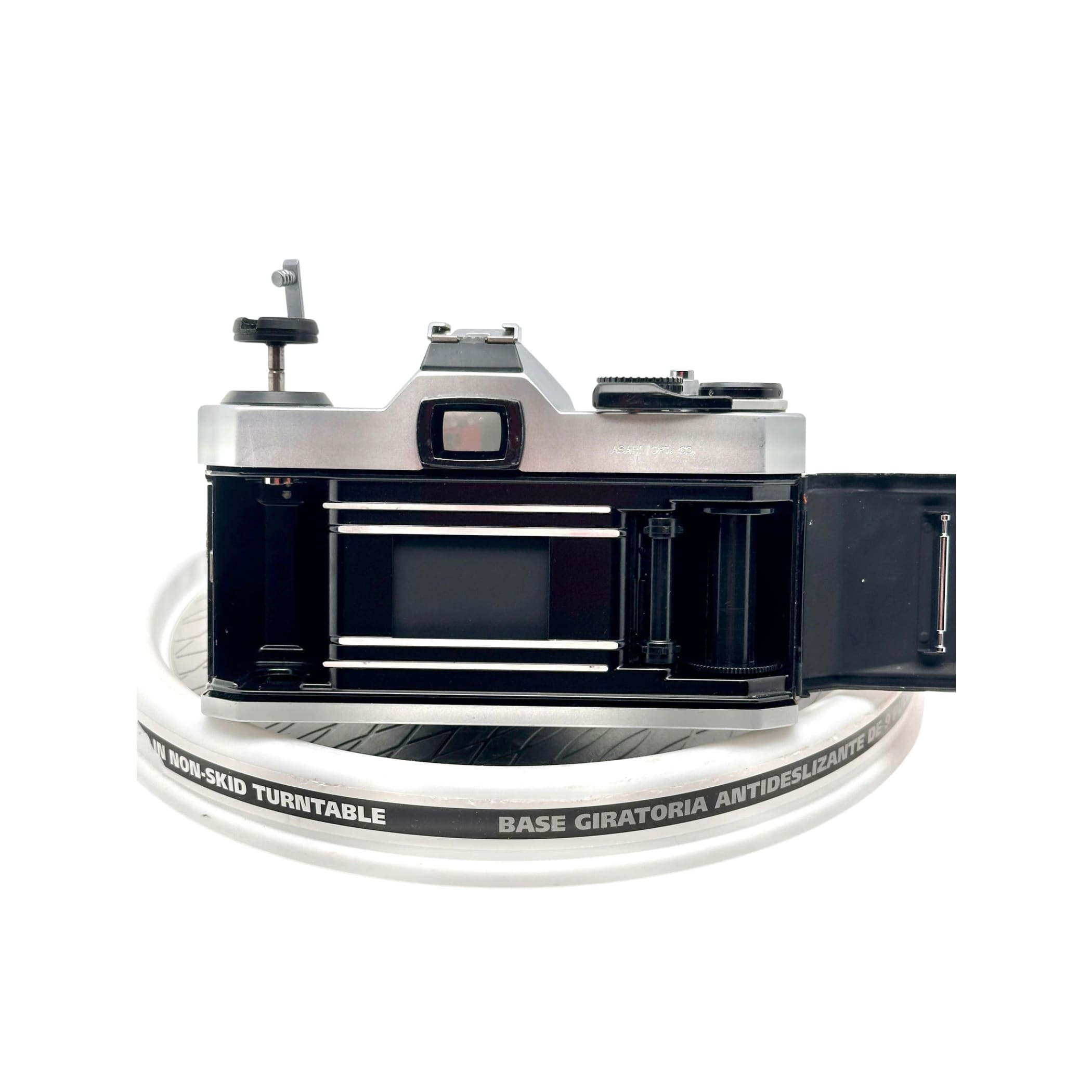 Silver-bodied canon ae-1 film camera with black accents and a visible shutter mechanism.