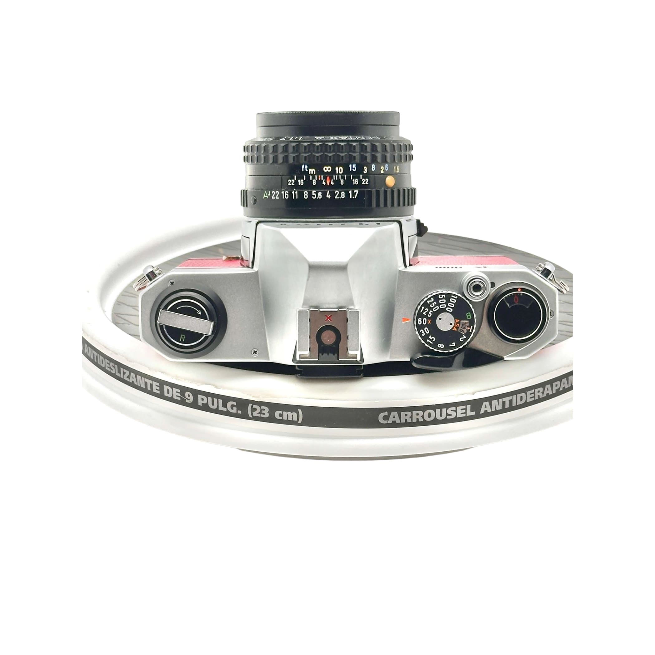 Silver and pink vintage film camera with a black lens, featuring manual focus rings and dials.