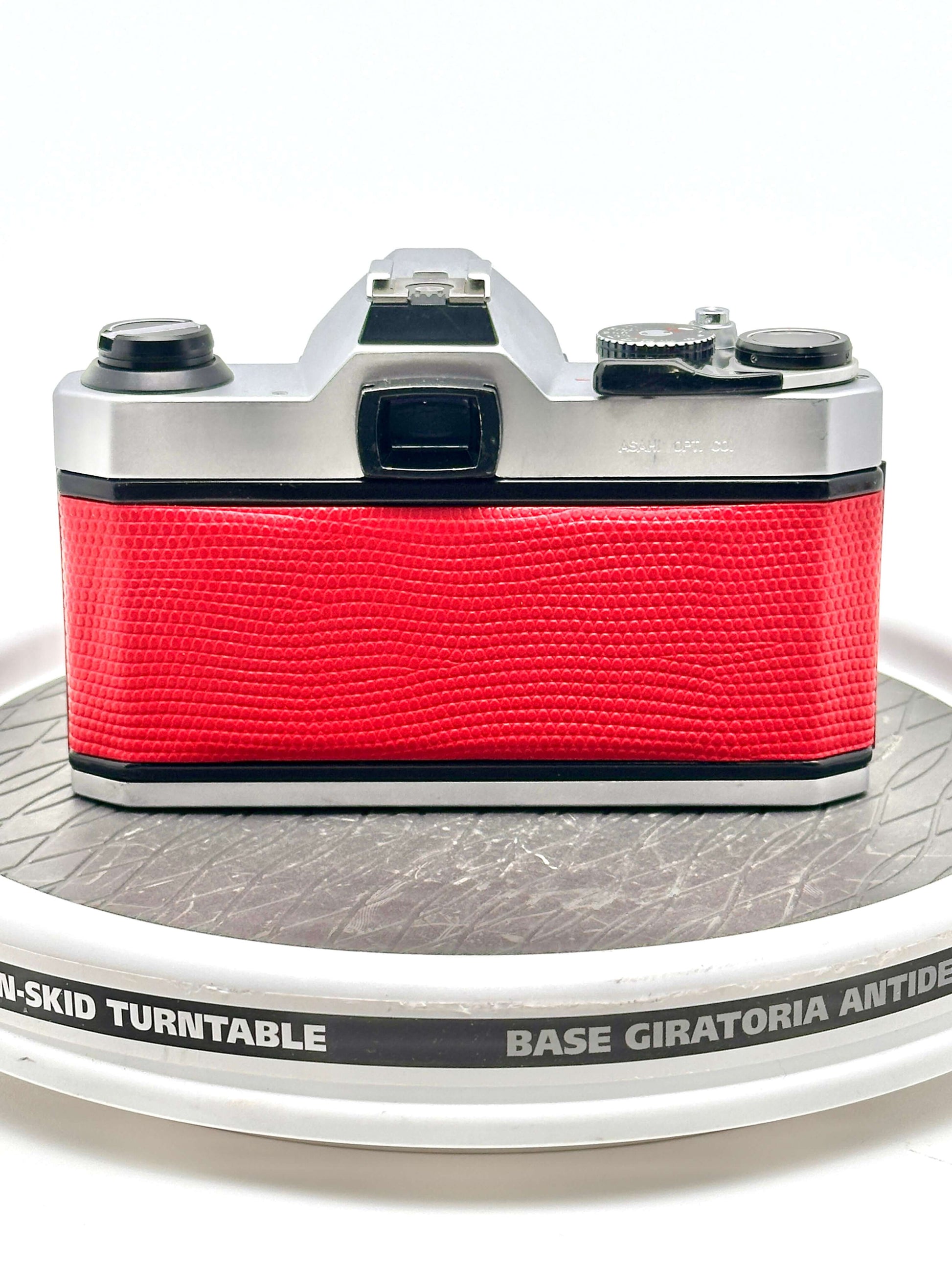 Back view of a Japanese Asahi Pentax K1000 red used 35mm film camera on a turntable.