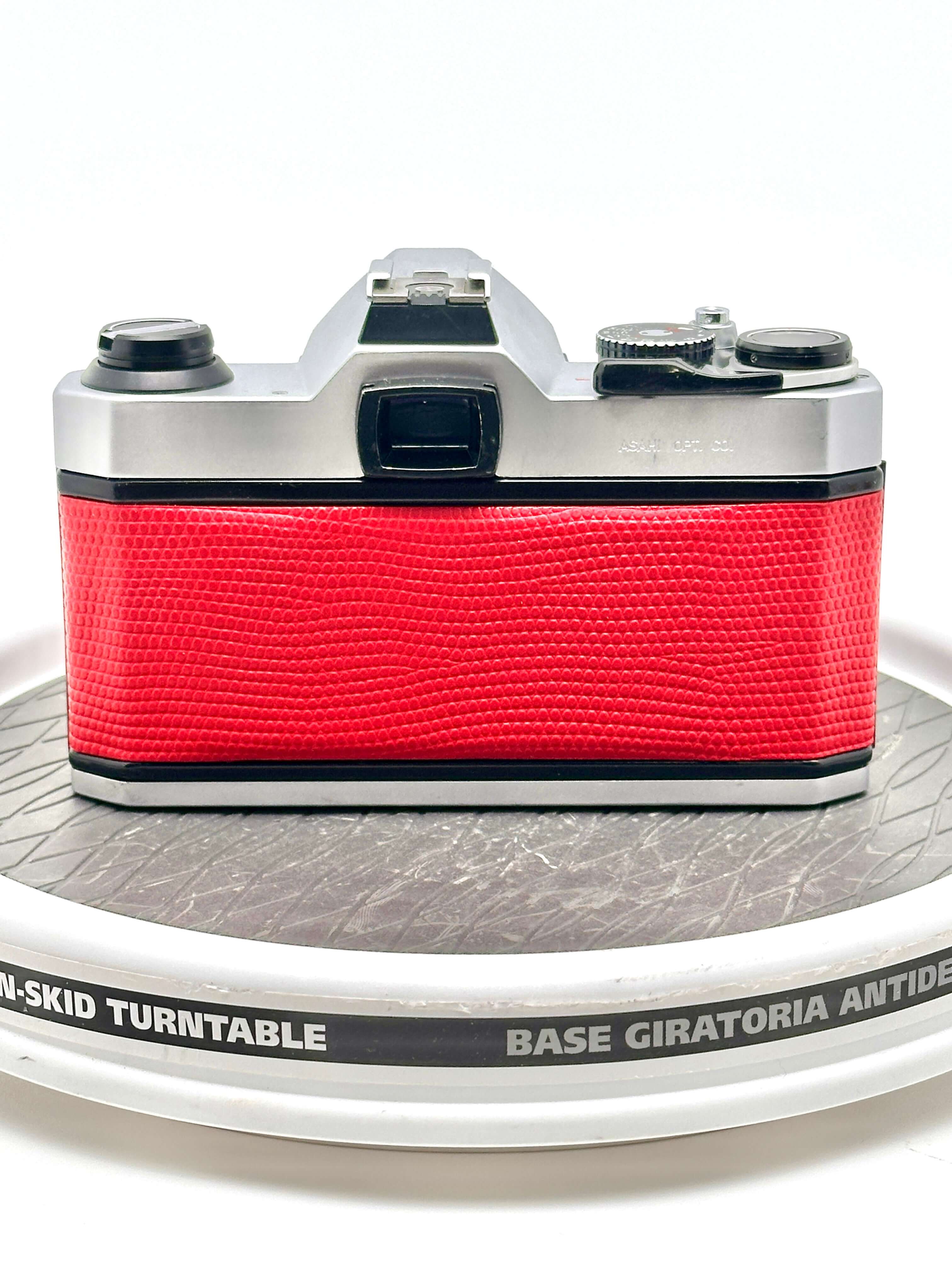 Back view of a Japanese Asahi Pentax K1000 red used 35mm film camera on a turntable.