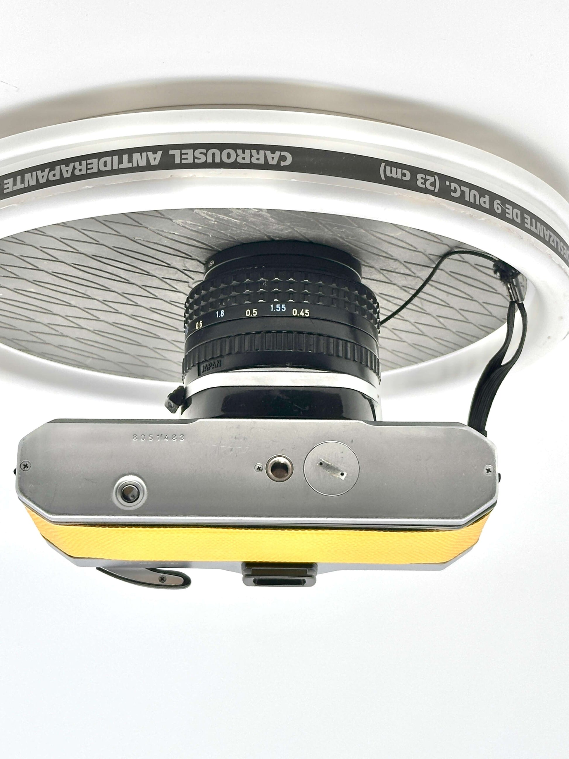 Japanese Pentax K1000 yellow film camera with 50mm f1.4 lens on white background, showcasing vintage photography design.