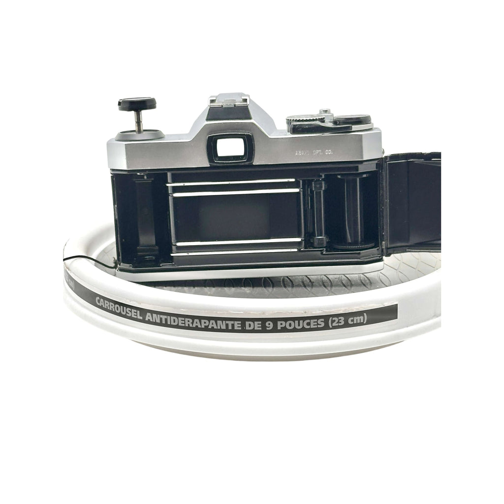 Silver and black vintage film camera with a classic rangefinder design, featuring metallic dials and a prominent viewfinder.