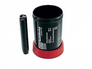 Black film developing tank with lid and red base for photography use.