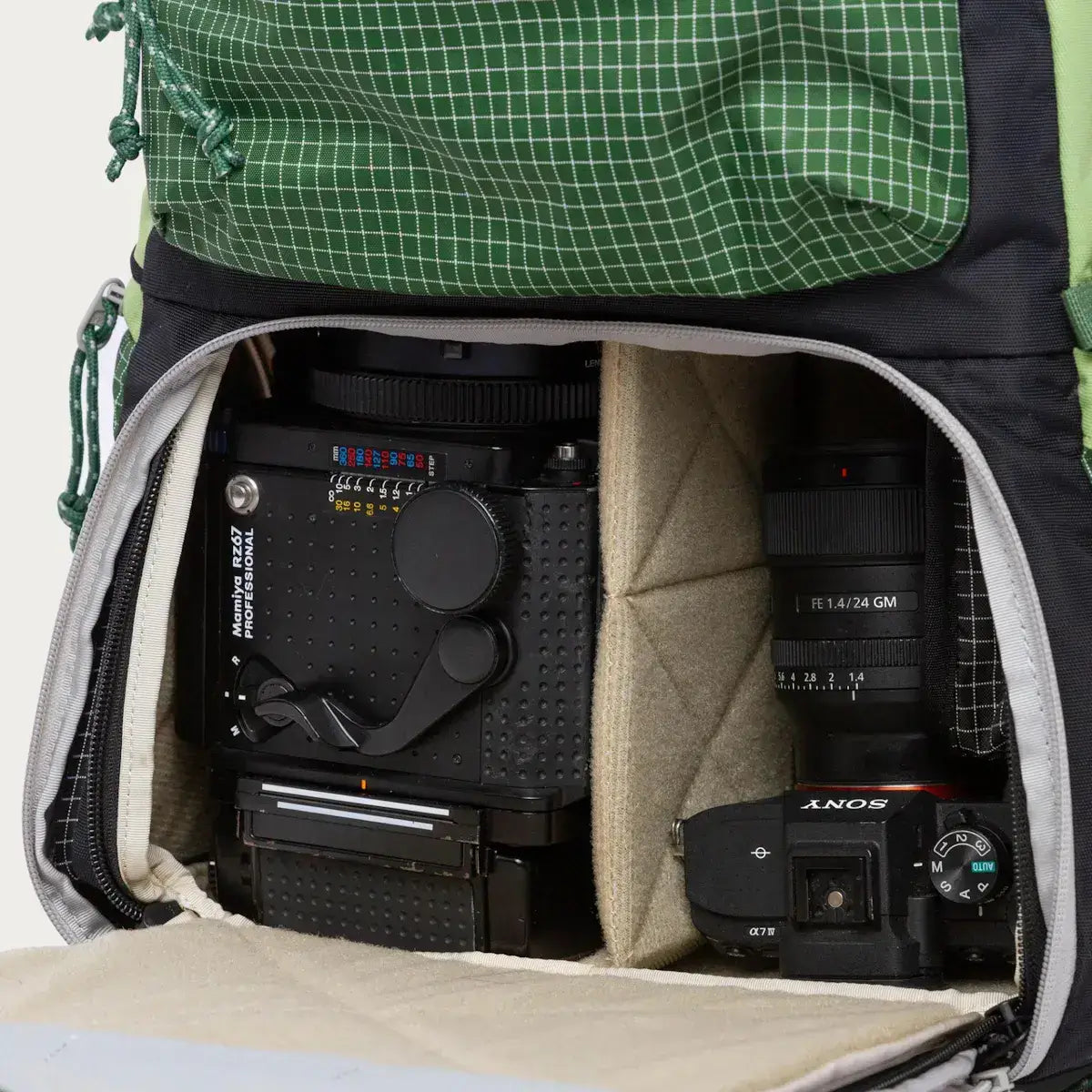 Open backpack showing a camera and lens compartments with professional photography equipment.