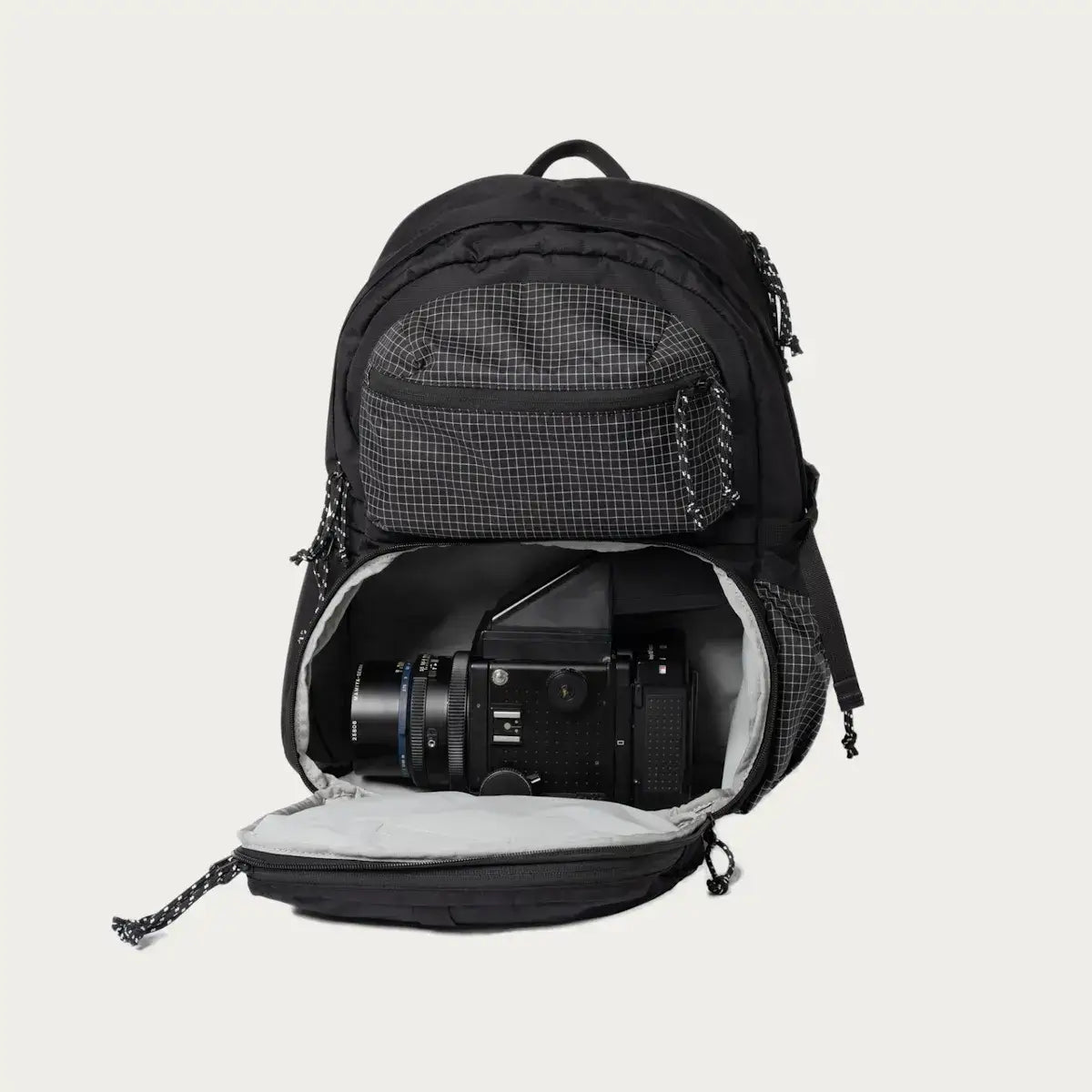 Black camera backpack with open compartment showing a camera inside.