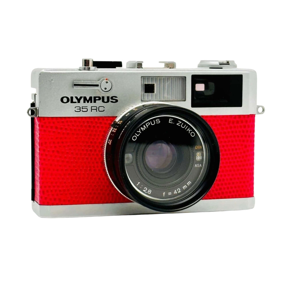 Red textured body with silver top and lens mount, featuring an olympus 35 rc camera equipped with a zuiko 42mm f/1.8 lens.