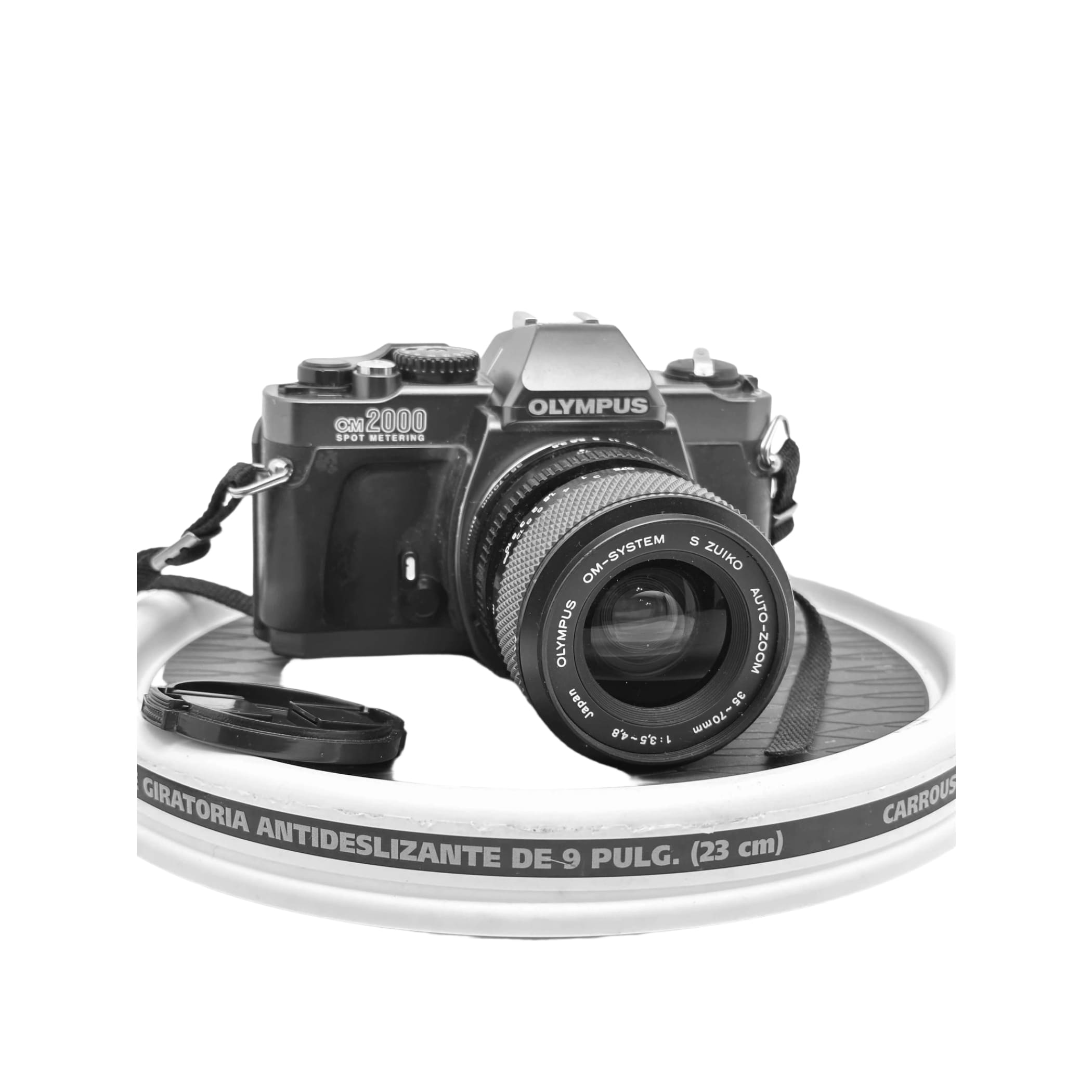 Black olympus om-2000 film camera with a zoom lens, featuring textured grip and classic dials.