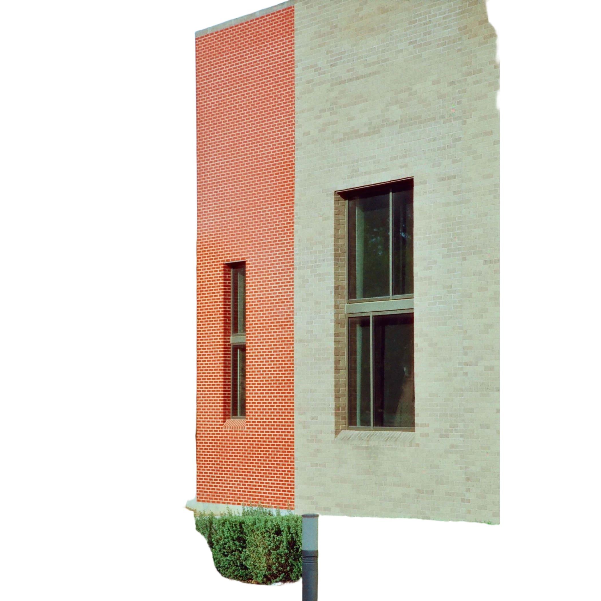 The building features a striking vertical red brick panel contrasting with beige brick walls, accented by dark-framed windows.
