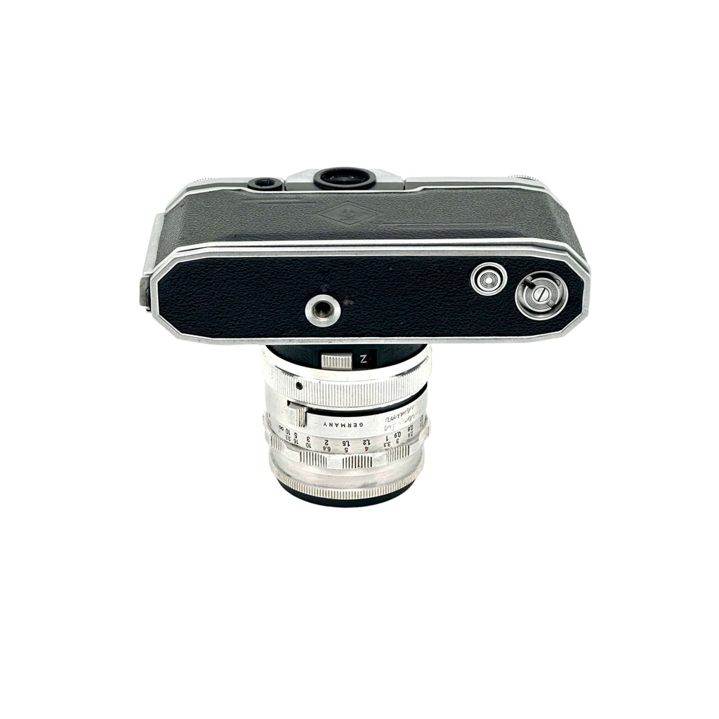 Silver and black leica camera body with a matching silver lens mounted on top.