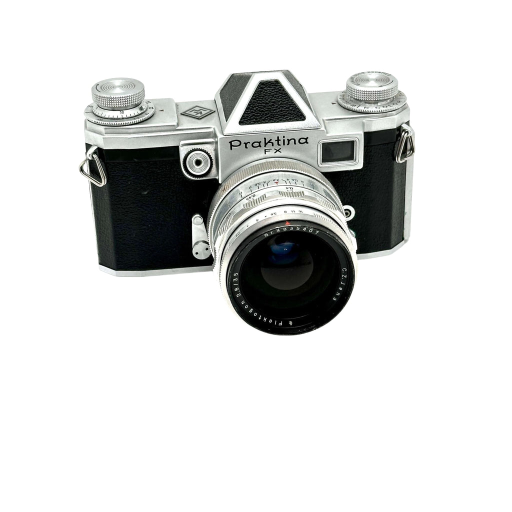 Silver and black praktica fx film camera with a textured leather grip and chrome accents.