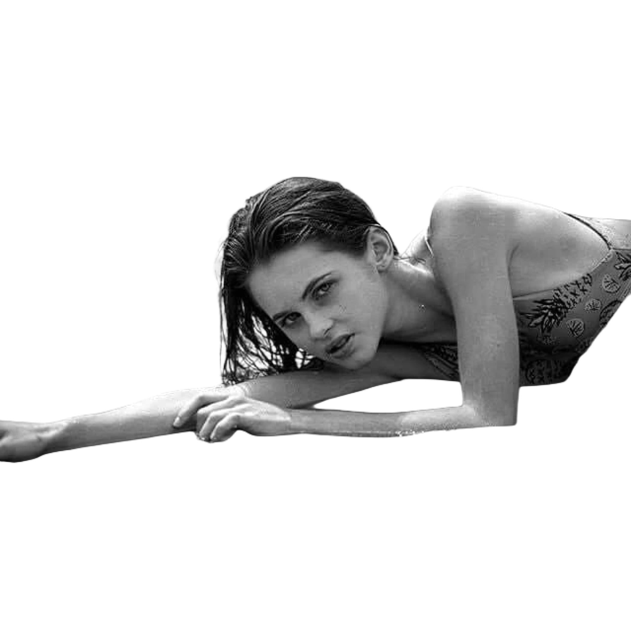 A black-and-white photograph of a woman in a patterned bikini top, partially submerged in water.