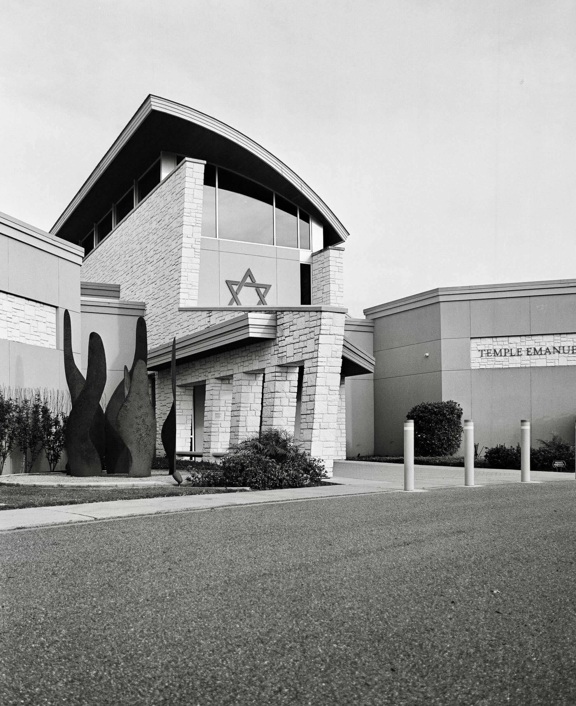 Exterior view of Temple Emanuel building featuring modern architecture and a Star of David symbol in black and white.