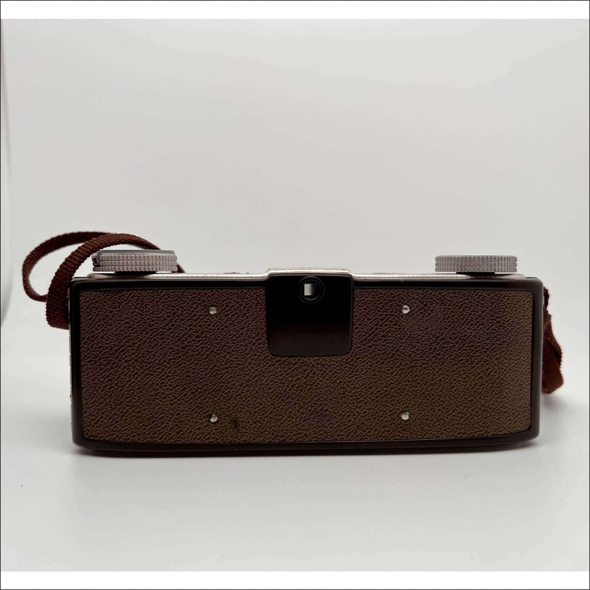 Vintage brown leather film camera with lens dials and strap.