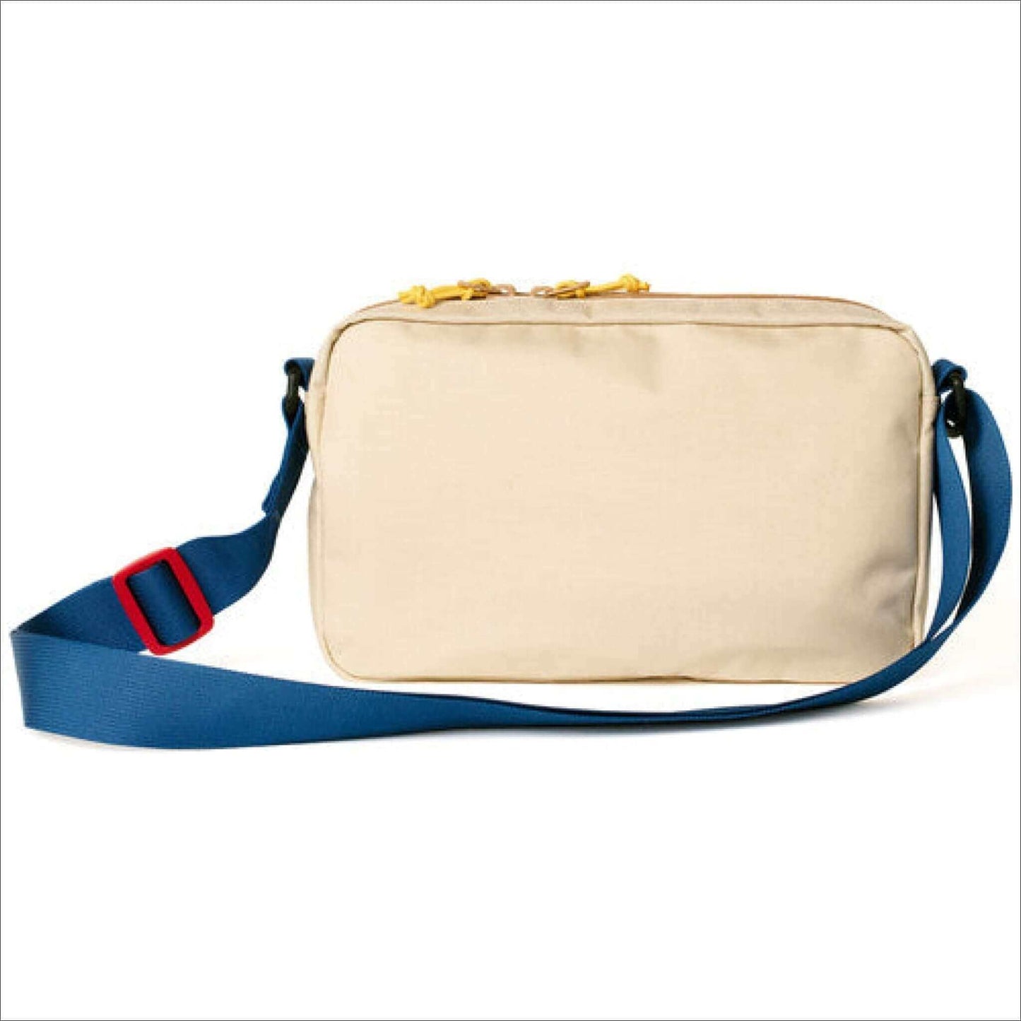 Cream shoulder bag with blue strap and red buckle, featuring yellow zippers on top.