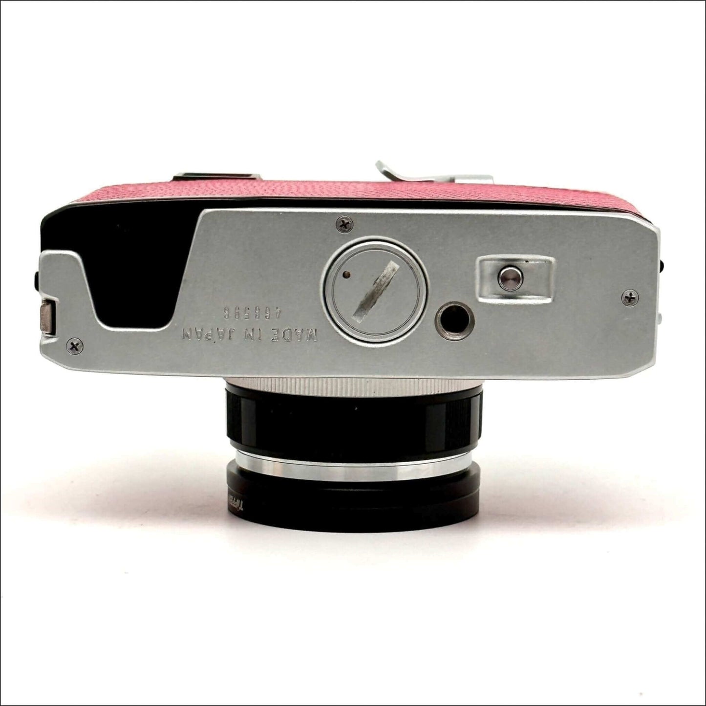 Bottom view of a vintage film camera with pink and silver body.