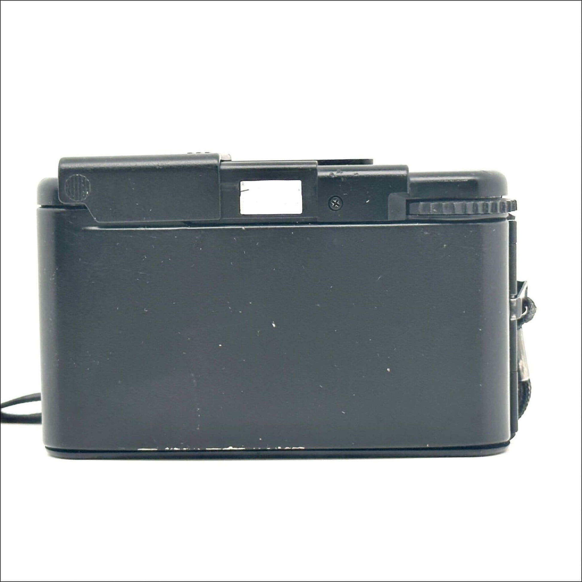 Back view of a vintage black film camera against a white background