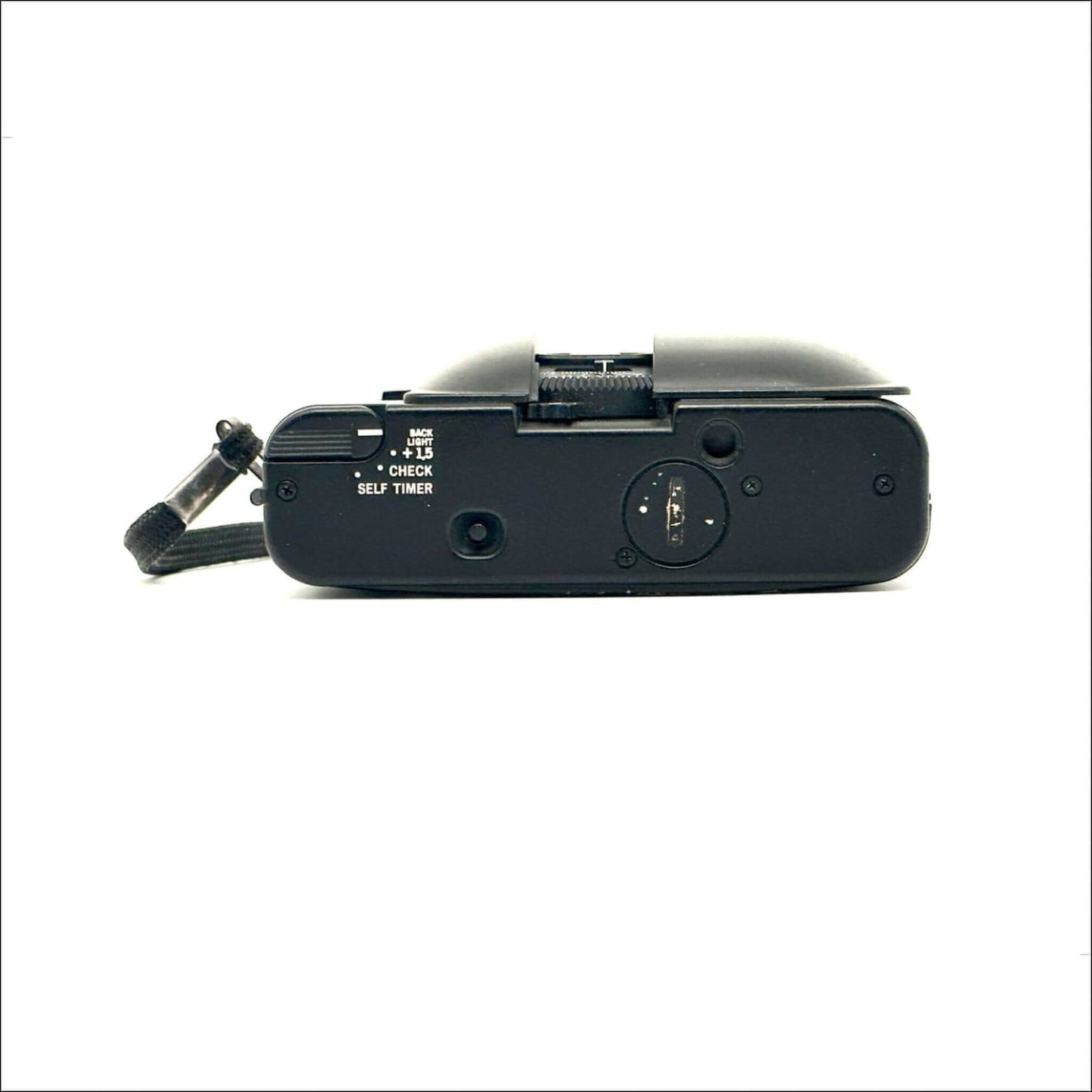 Vintage black camera with timer and film indicator lying flat on a white surface.