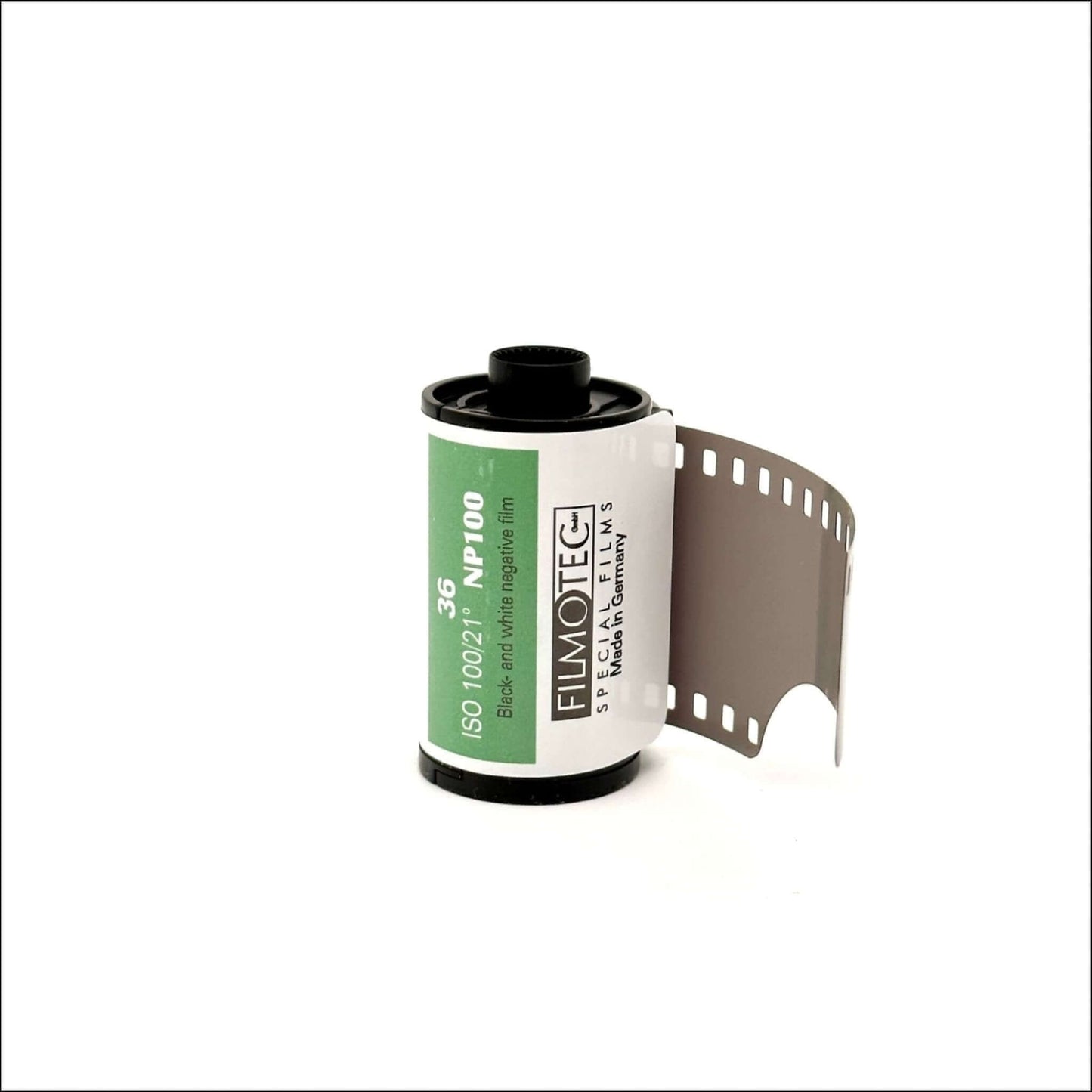 Black and white negative film roll with green label and exposed film strip showing sprocket holes against a white background